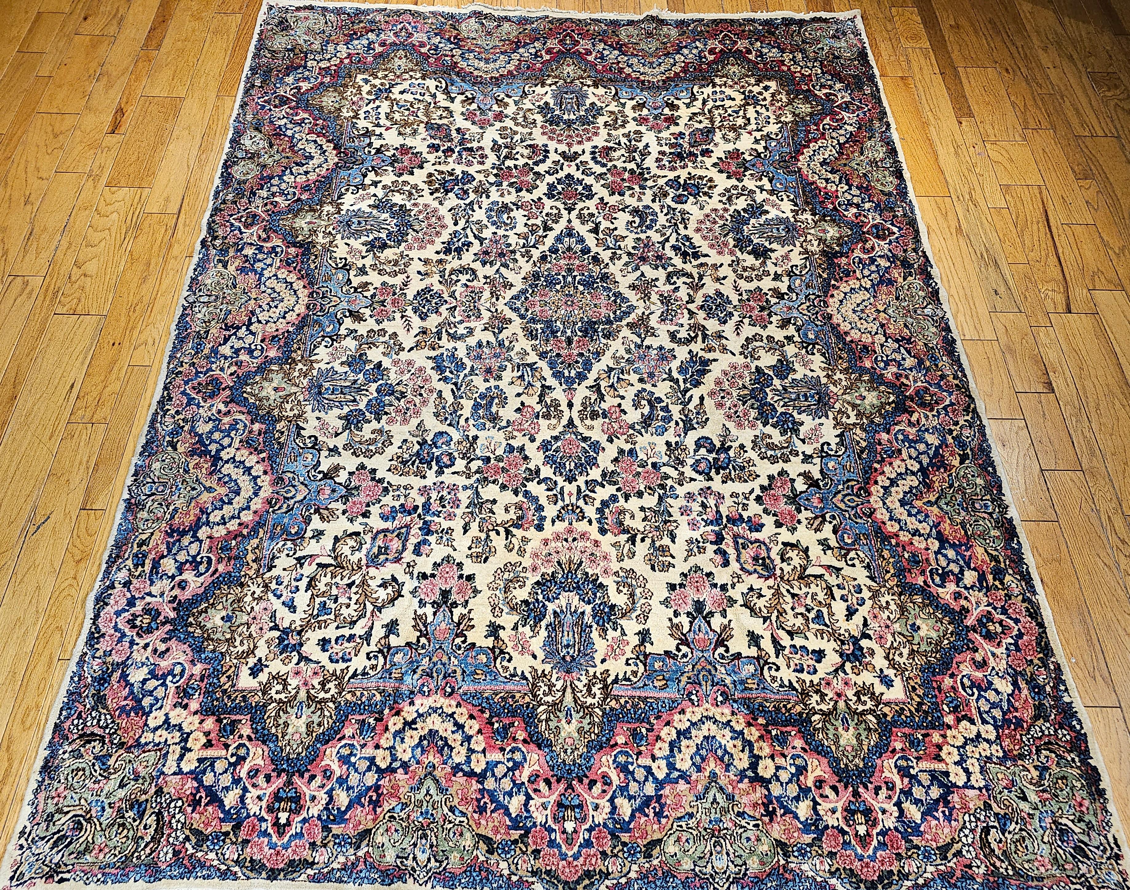 Dieser persische Kerman Lavar-Teppich im Vintage-Stil, ein raumgroßes Meisterwerk aus den frühen 1900er Jahren, ist von zeitloser Eleganz. Mit seinem floralen Allover-Muster in sanften, garteninspirierten Farbtönen erinnert dieser exquisite Teppich