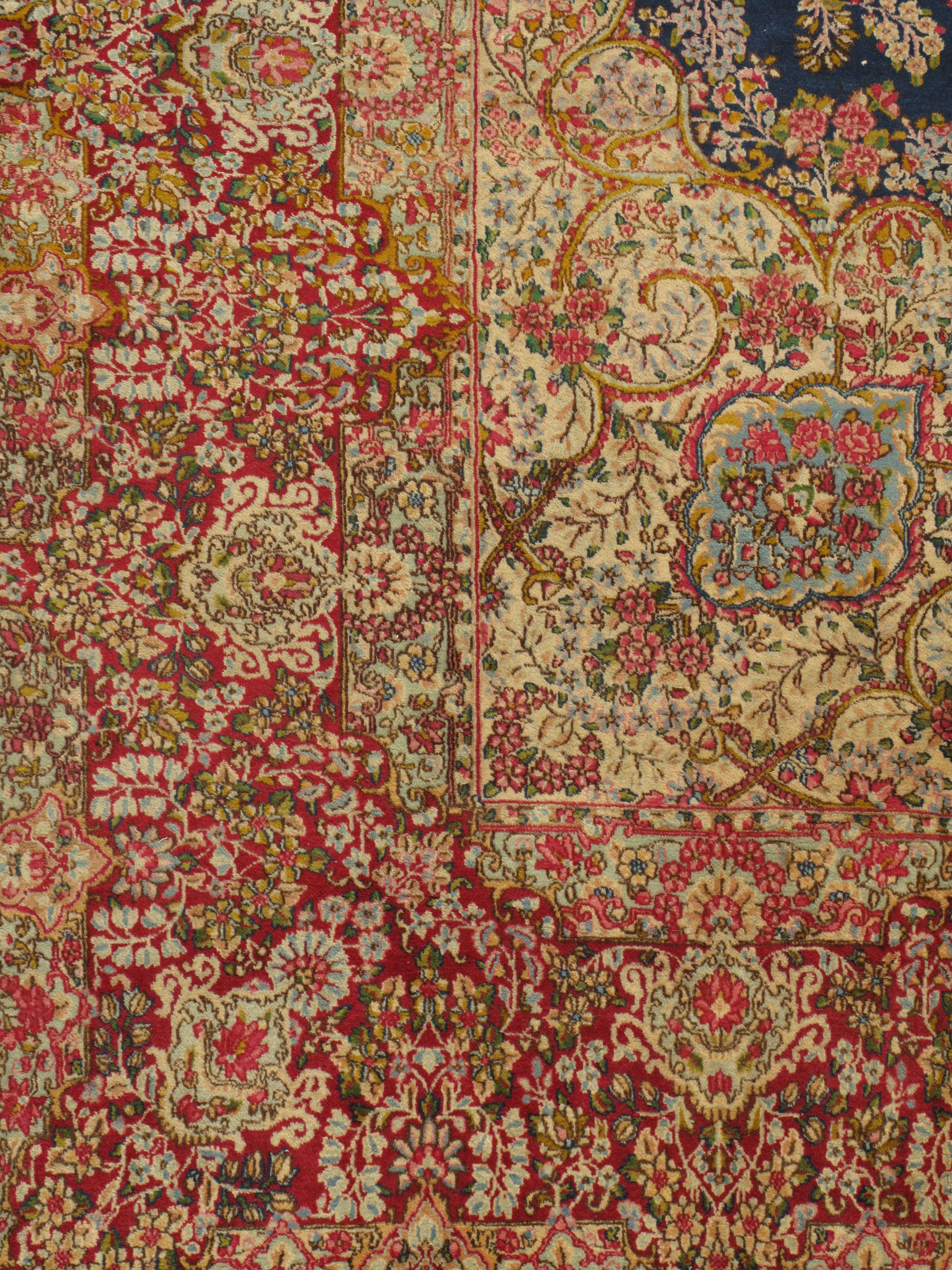 Tapis Persan Kerman vintage, circa 1920, 9'7 x 12'7. Les détails de cet exquis tapis persan Kirman des années 1920 témoignent du travail d'un véritable maître tisserand. La bordure se fond dans le champ et le contour central bleu foncé contribue à