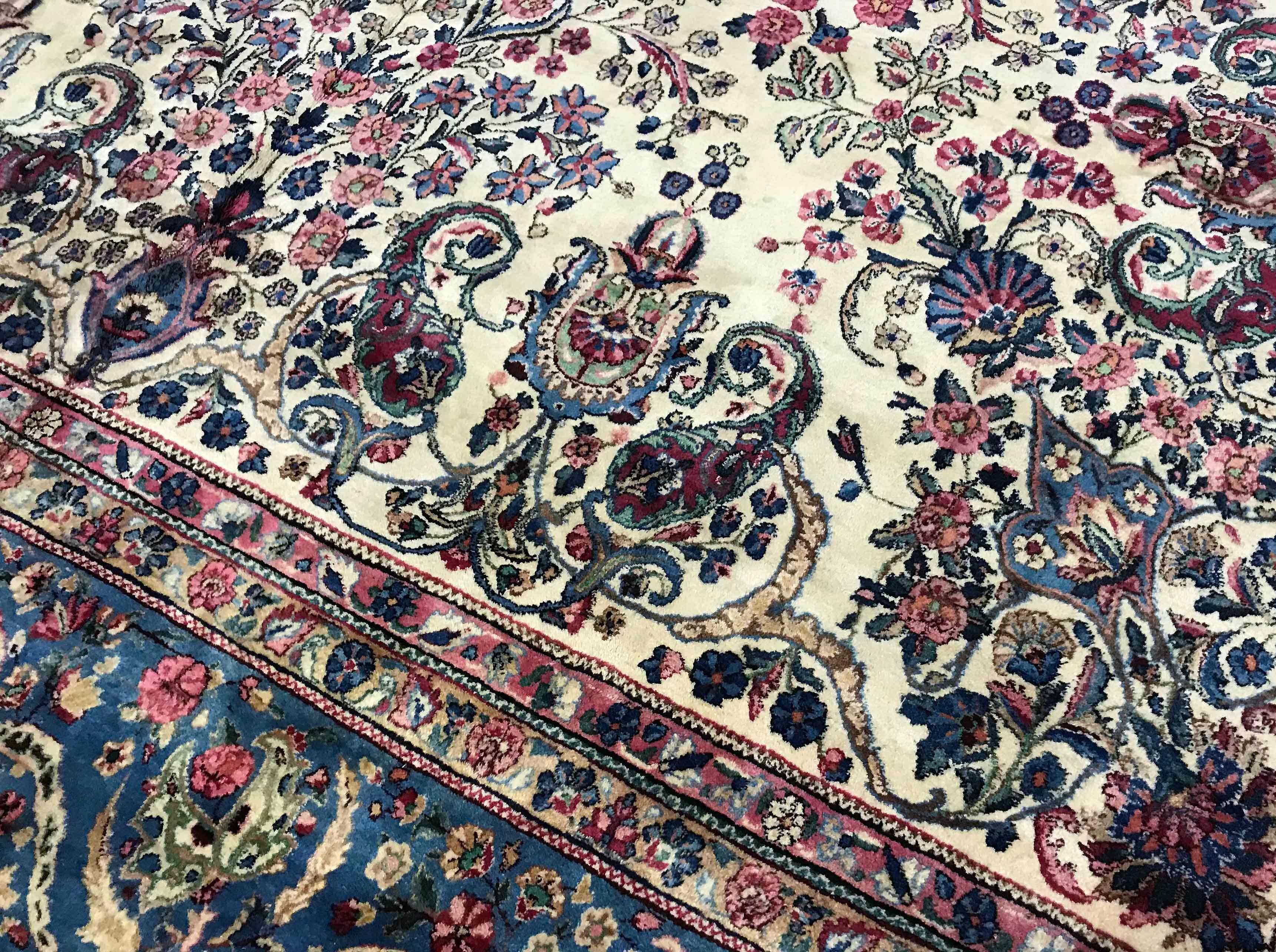 Vintage Persian Kerman rug, circa 1940. The ivory field filled to overflowing with floral designs within a powder blue border that completes this harmonious look.