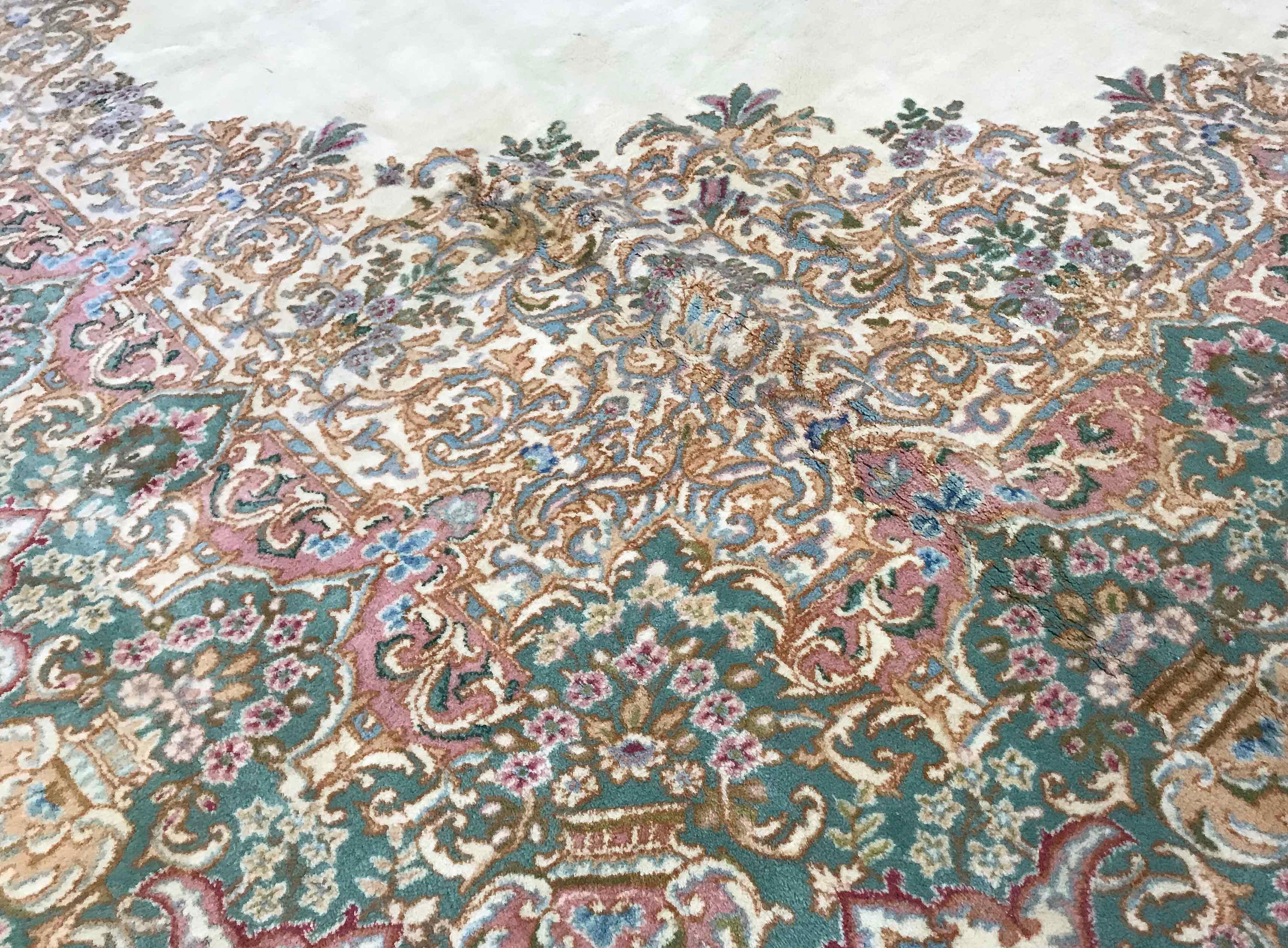 Vintage Persian Kerman rug, circa 1940. A classic look to this oversize Kerman rug with a soft ivory field incorporating a central design which is repeated around the sides and border in rich detail that shows up this rug as of the highest quality.