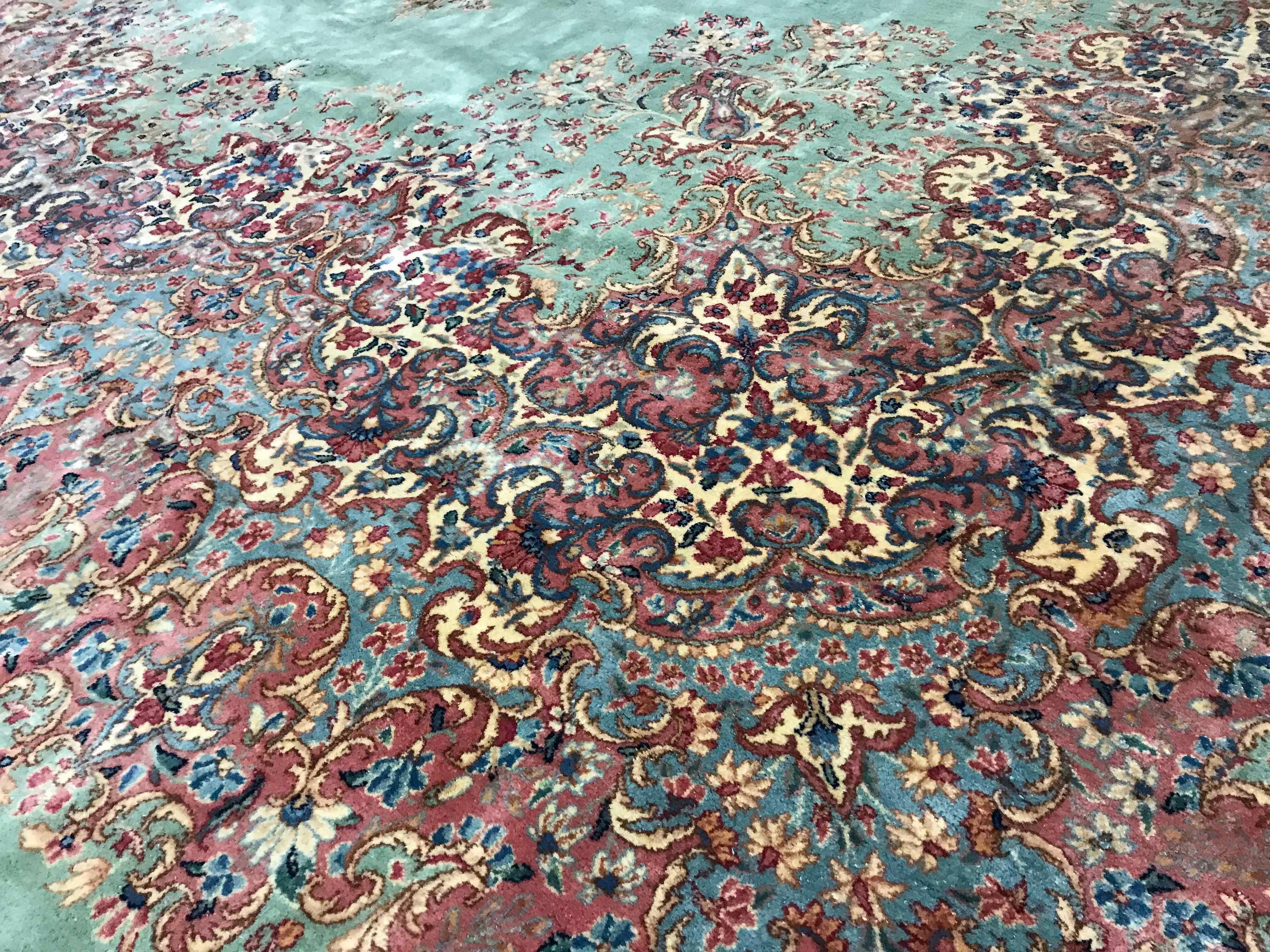 Vintage Persian Kerman rug, circa 1940. On a wonderful soft green ground is an intricate floral central medallion which is repeated in the borders to create this rug of subtle distinction and style that will reflect beauty in any room it is placed.