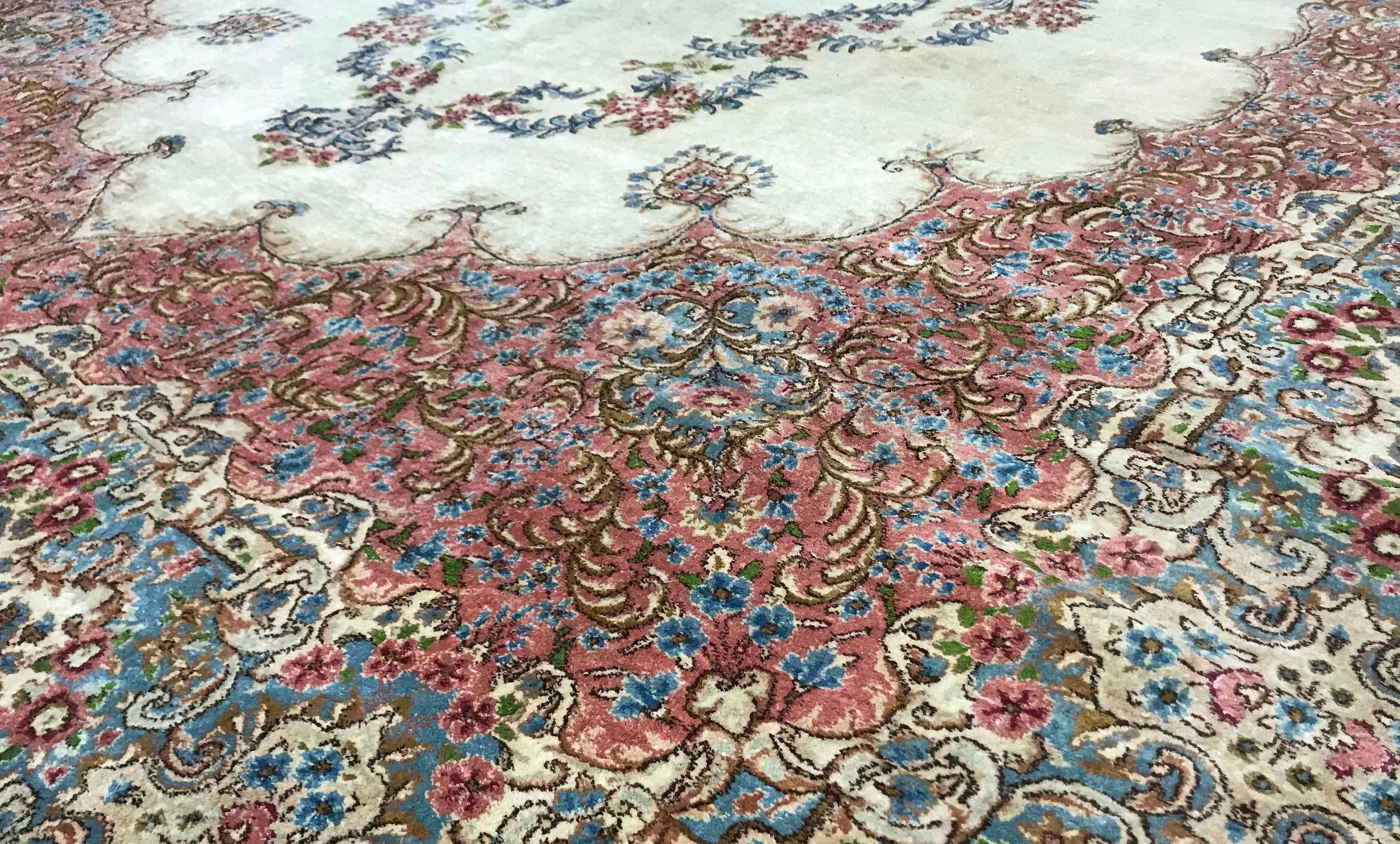 Vintage Persian Kerman rug, circa 1940. The ivory field containing soft floral designs all enclosed within a gentle rose and green swirling border to complete this gentle picture and wonderful looking rug. Size: 10'4 x 17'10.
 