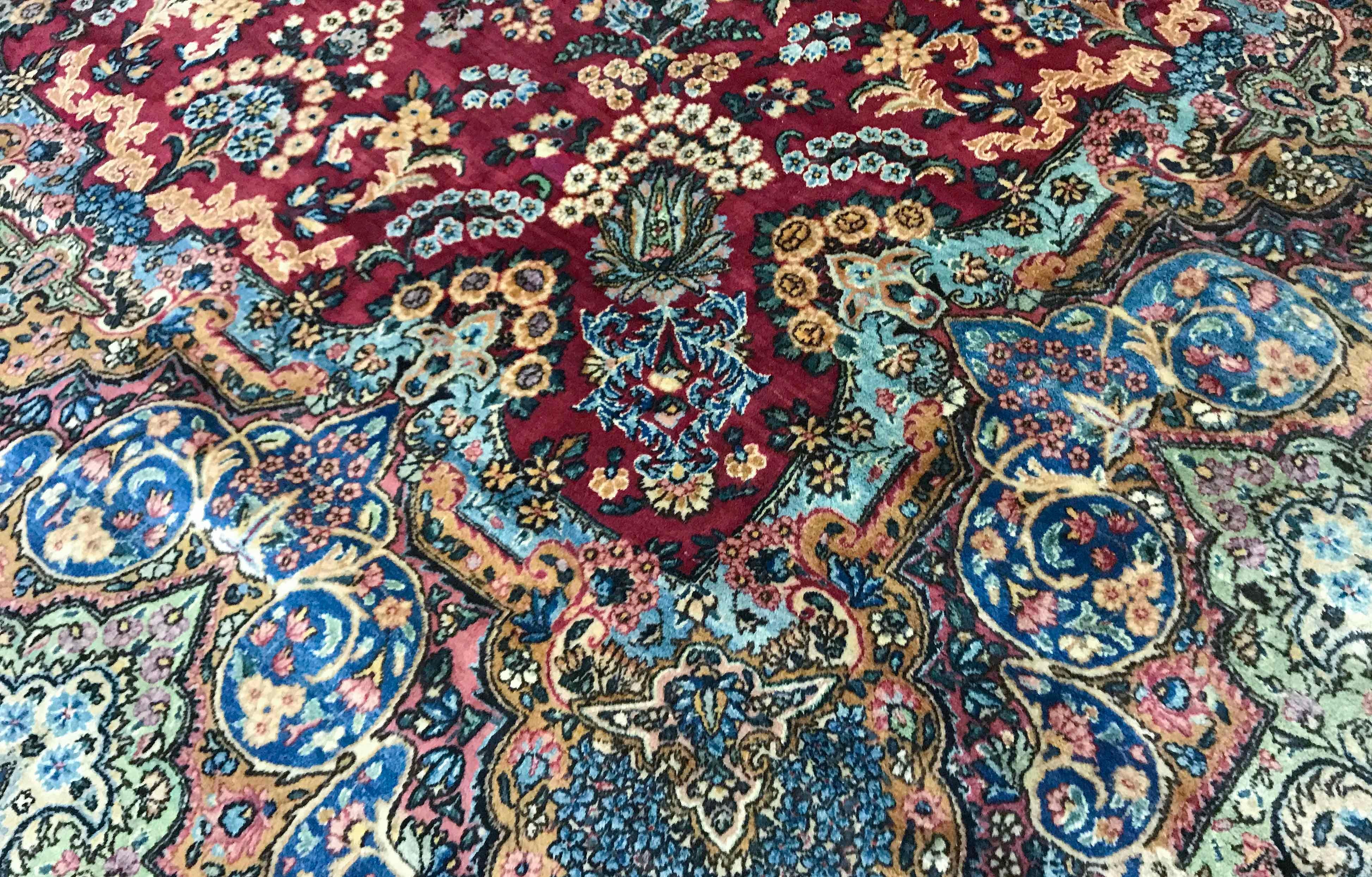 Vintage Persian Kerman rug, circa 1940. The astonishing detail in this rug is a testament to the master weavers who created the piece. The central red ground bursting with superb floral designs and enclosing a central shape resembling a piece of