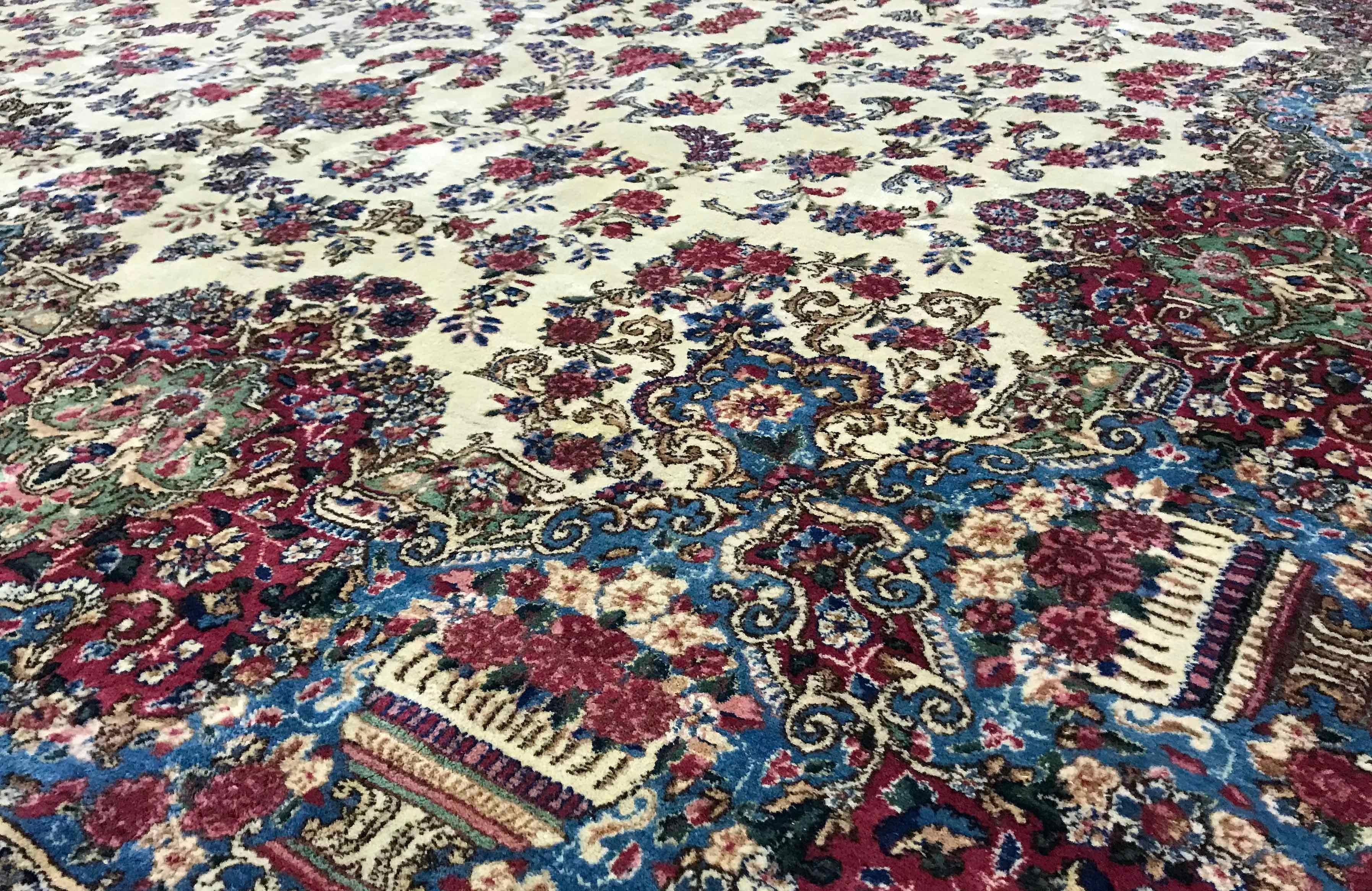 Alfombra persa Kerman vintage, circa 1940. Esta alfombra tiene un limado central maravillosamente suave, lleno de diseños florales que rodean un medallón central en azules suaves que se extiende hasta el borde para crear una sensación relajada y