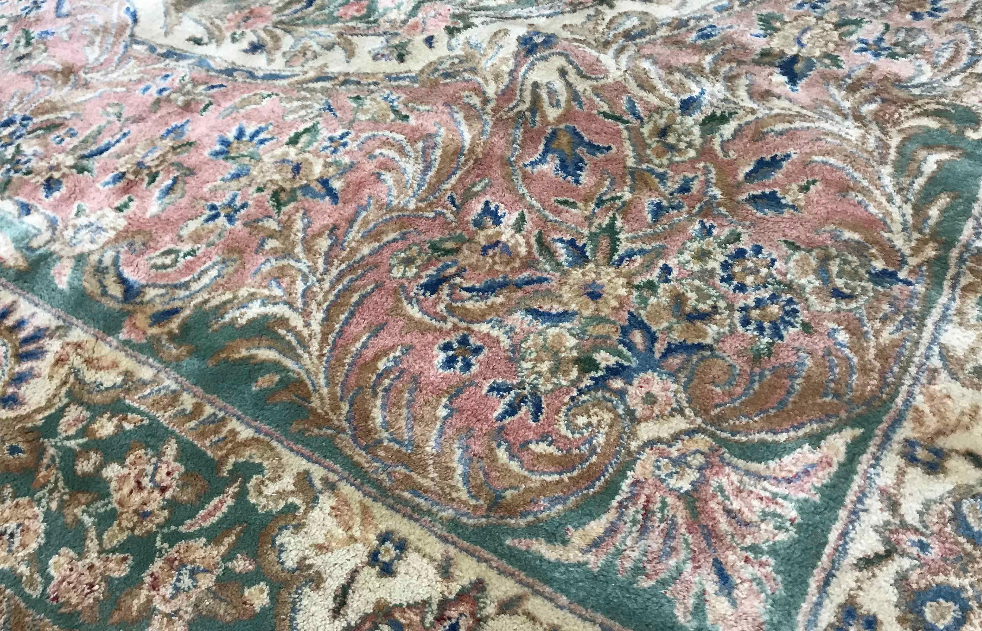 Alter persischer Kerman-Teppich, um 1940. Ein weicher und doch subtiler Teppich, der sanfte Farben mit einem detaillierten Design kombiniert. Das zentrale grüne Feld mit Medaillon ist von rosafarbenen Tönen und einer elfenbeinfarbenen Bordüre