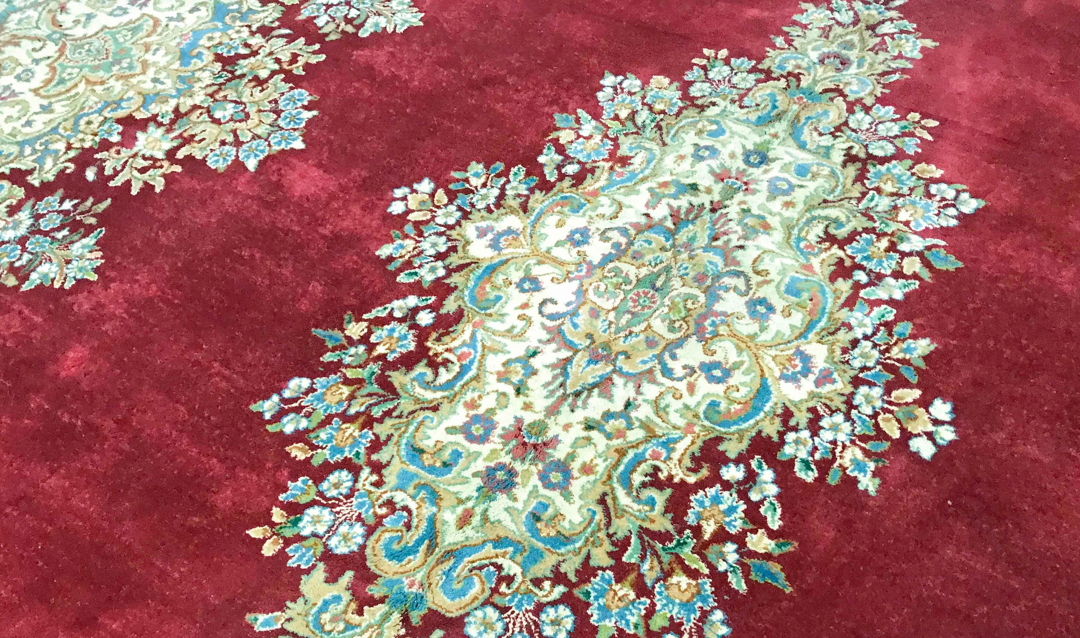 Alter persischer Kerman-Teppich um 1940. Die schlichte rote Füllung, die das zentrale Medaillon umgibt, das bis zum Bersten mit Blumen gefüllt ist, umrahmt von einer Bordüre und Ecken, die den floralen Stil wiederholen, ergeben ein wunderbares Bild,