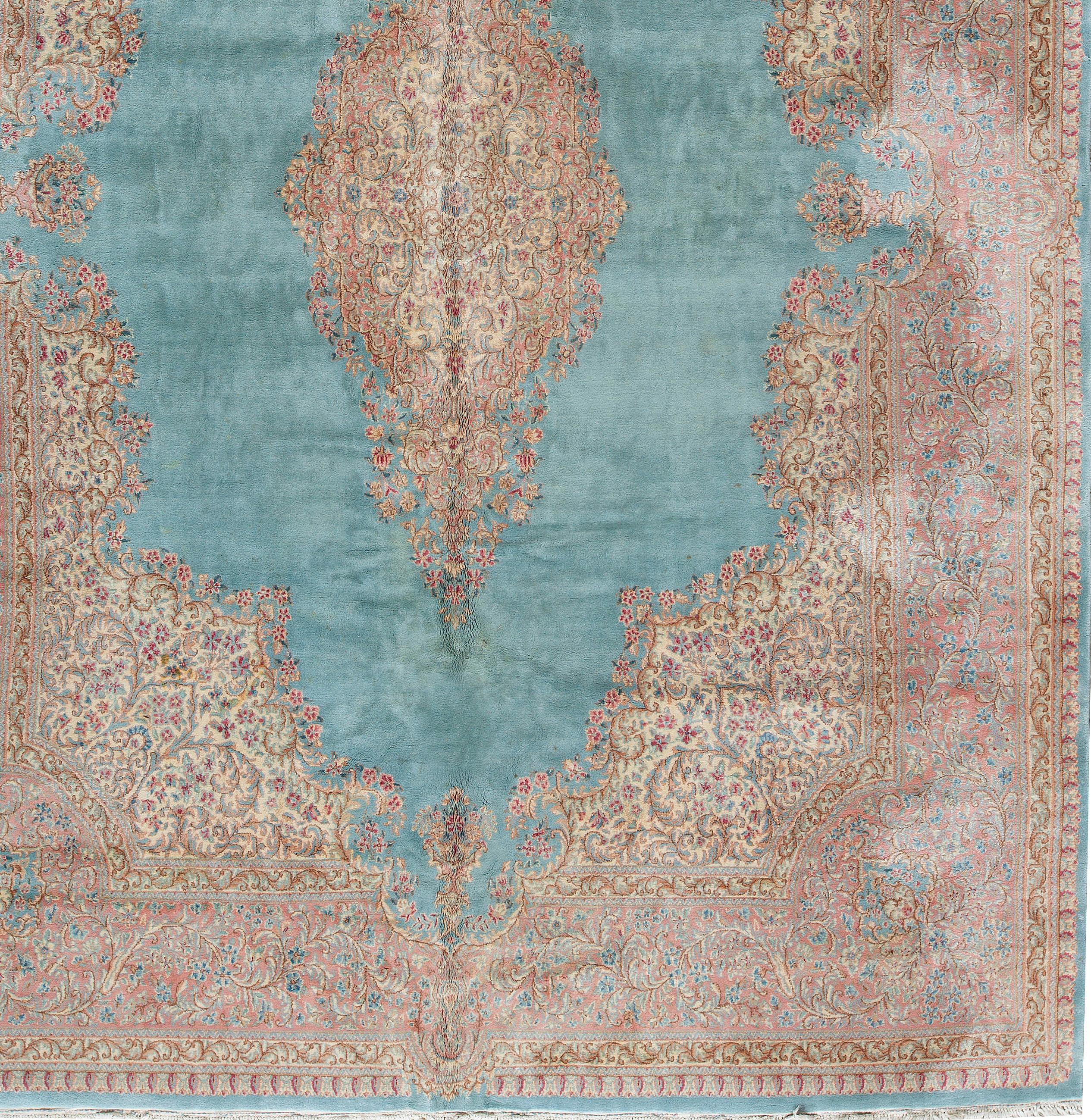 Vintage Persian Kerman rug, circa 1940. A Kerman rug with a soft blue ground having a light multicolored central design repeated in the borders this rug will create a sense of style and character to any area it is placed. Size:11'7 x 15'7.