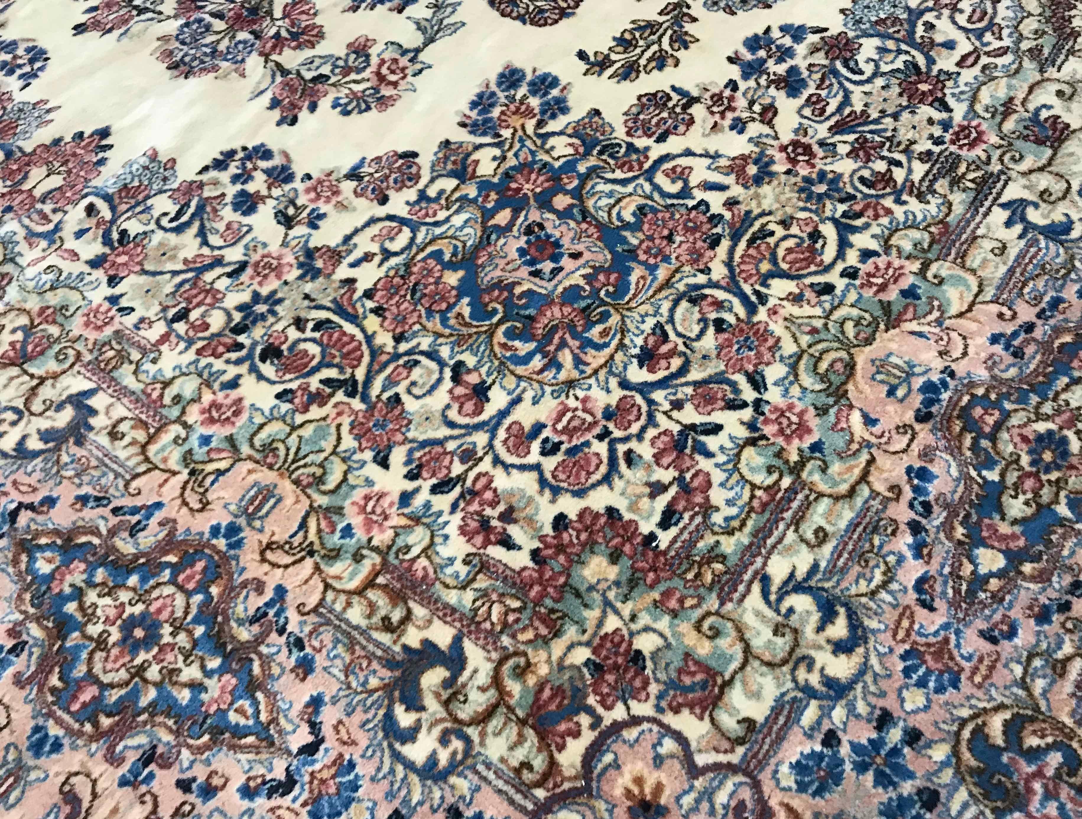 A large Kerman rug the ivory field with a central medallion in soft pastel shades encircled by floral and vine designs surrounded by detailed flower patterns which merge into the border. The skill of the weavers is shown by the wonderful eye for