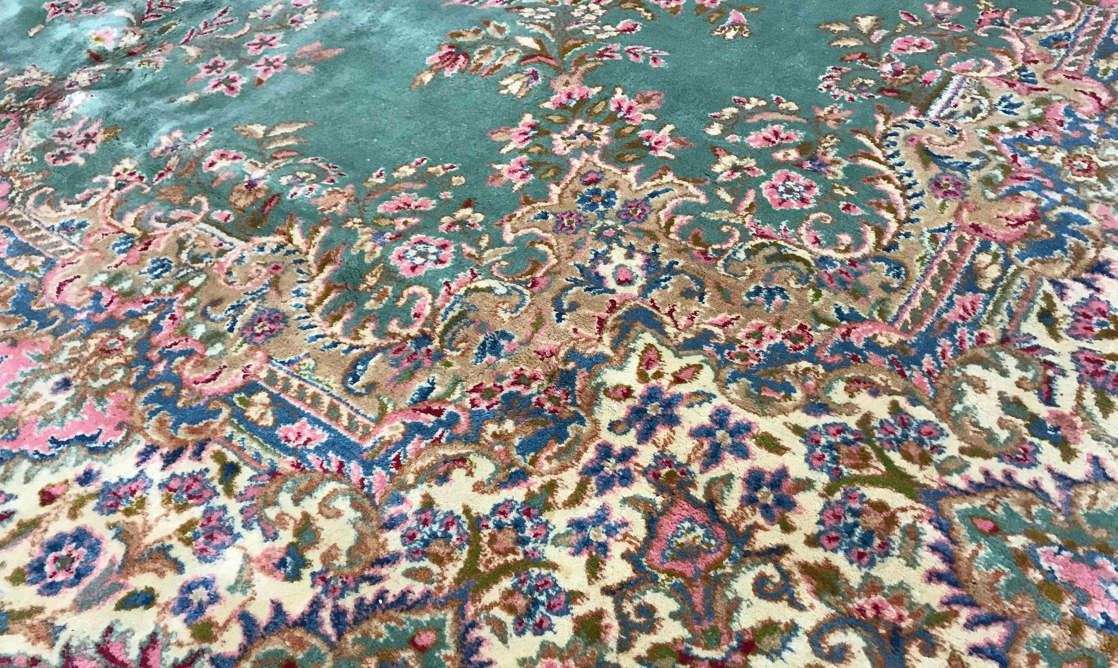 Vintage Persian Kerman rug, circa 1940. A wonderful composition to this rug with the soft green field both enclosing and surrounded by floral designs in soft gentle rose and blues to create this rug with a gentle style and look. Size: 8'11 x 12'9.