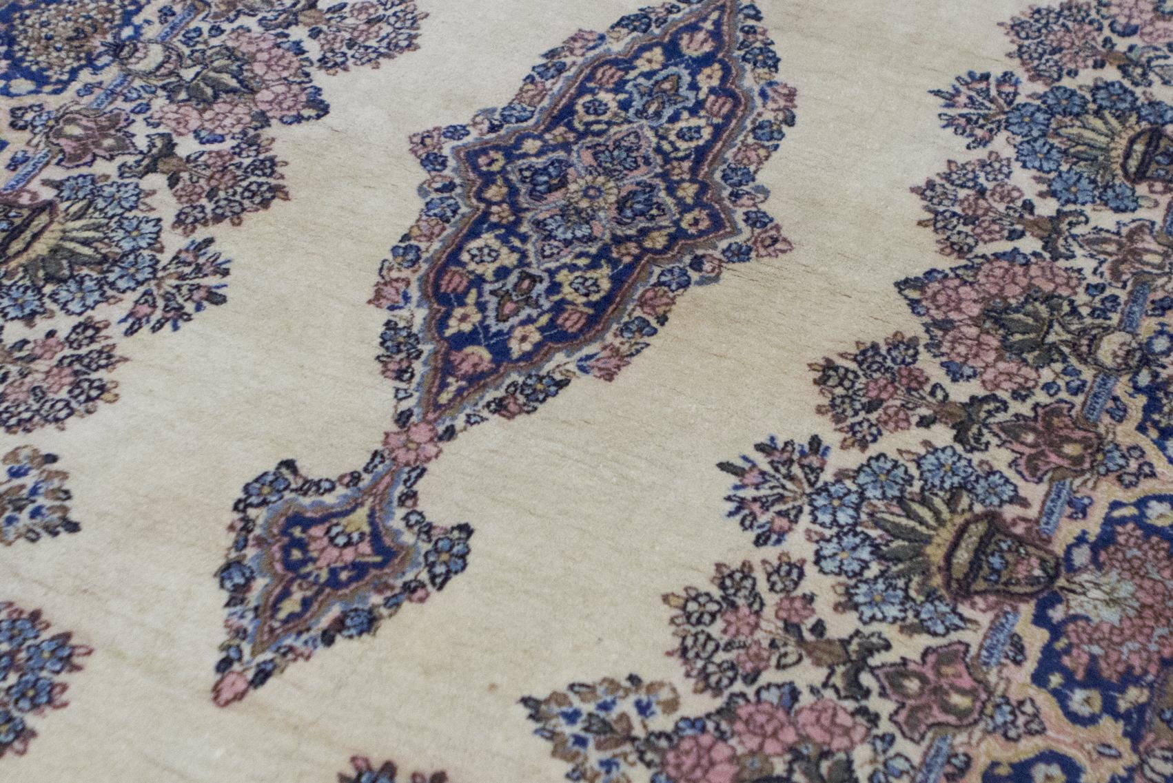 Tapis persan Kerman vintage, circa 1940. Bien que de petite taille, ce tapis vintage Kerman intègre une quantité énorme de détails dans la composition avec les éléments floraux répétés dans le médaillon et les bordures environnantes, le champ ivoire