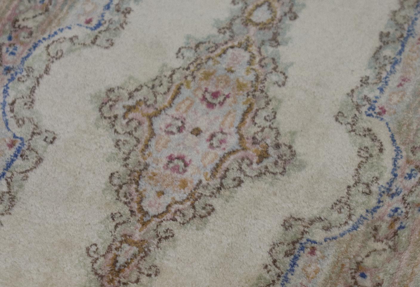 Tapis persan Kerman vintage, circa 1940. Bien que de petite taille, ce tapis vintage Kerman intègre une quantité énorme de détails dans la composition avec les éléments floraux répétés dans le médaillon et les bordures environnantes, le champ ivoire