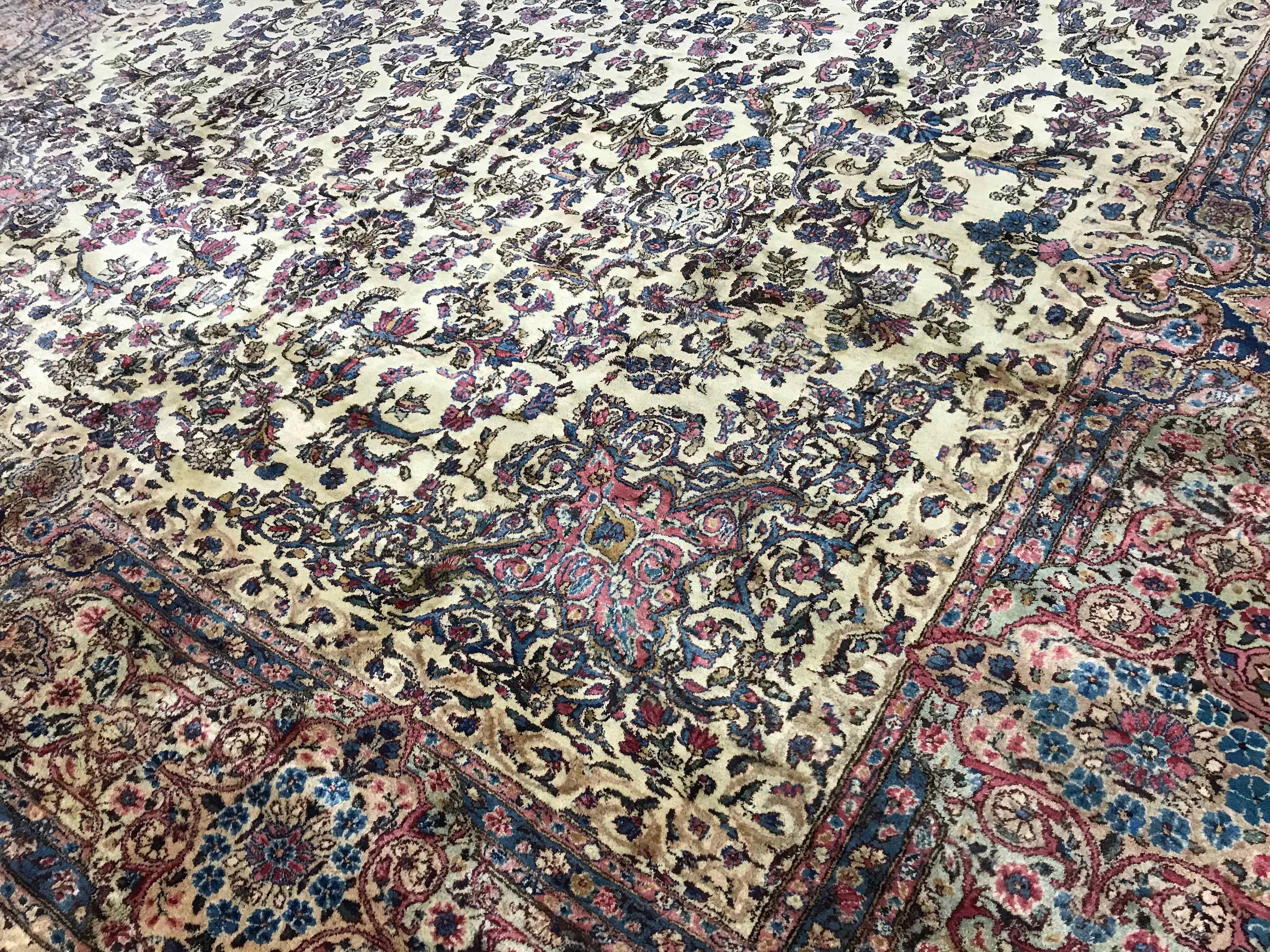 Tapis persan Kerman vintage, circa 1940. Un look classique pour ce tapis Kerman surdimensionné avec un doux champ ivoire incorporant un motif central qui est répété sur les côtés et la bordure avec de riches détails qui montrent que ce tapis est de