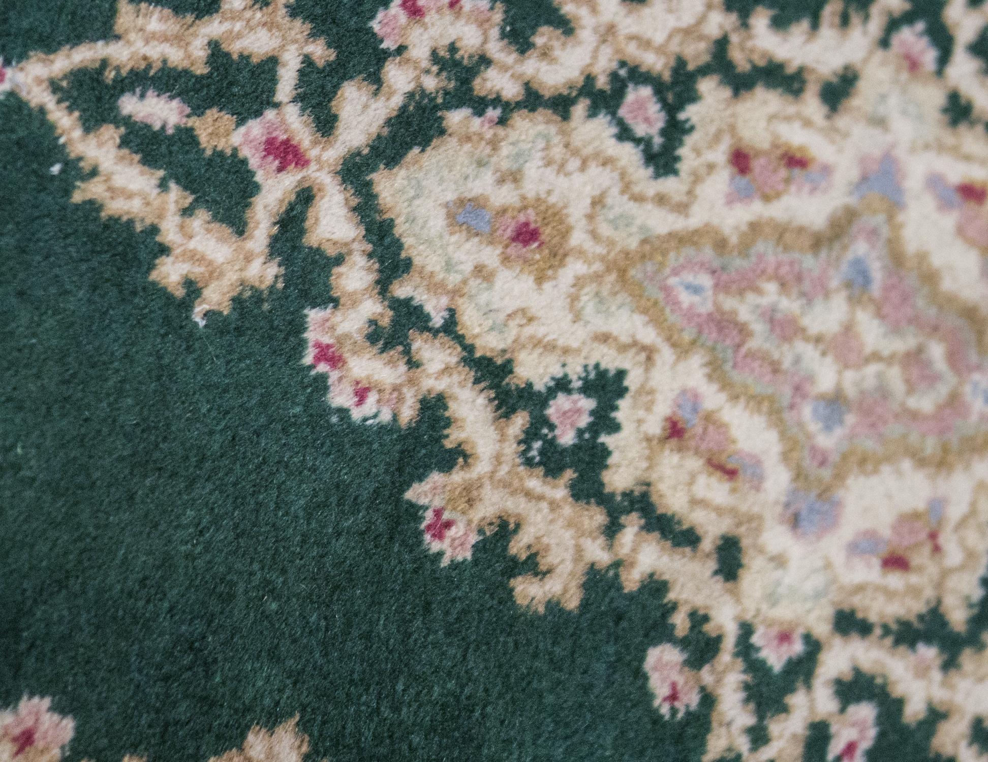Alter persischer Kerman-Teppich, um 1940. Ein kleiner Kerman-Teppich, der das Design der größeren Teppiche im Übergrößen-Stil kopiert. Der grüne Grund mit seinem zentralen Medaillon ist typisch für Kerman-Teppiche aus dieser Zeit. Größe: 1'11 x 3'10