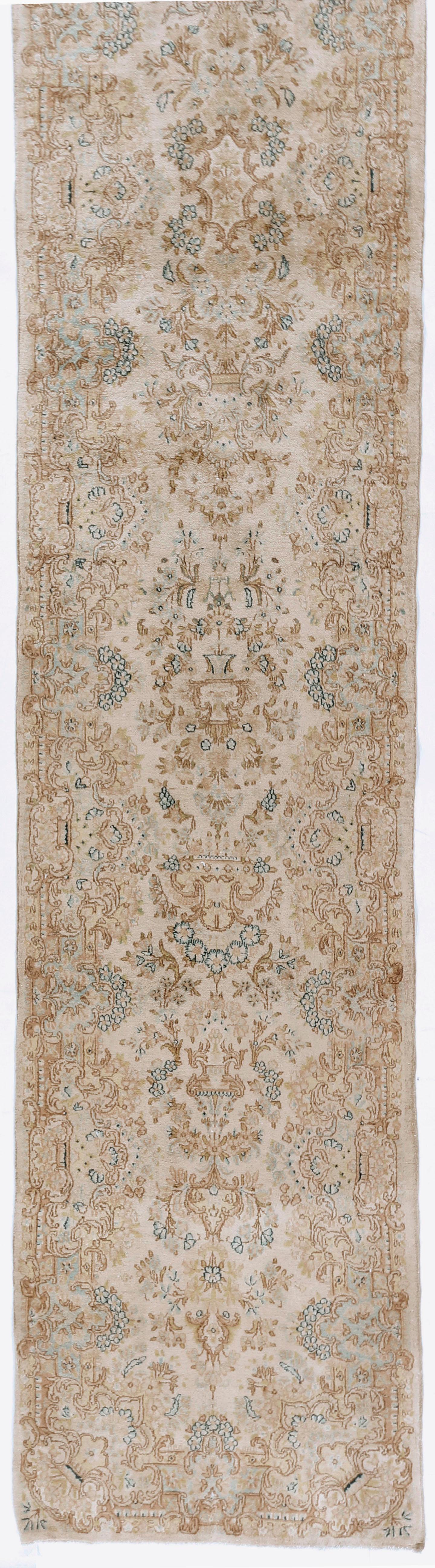 Vintage Persian Kerman runner 2'10 x 18'10. A soft and gentle design on an ivory field which blends in with the border to create this handwoven Kerman rug from Persia.
