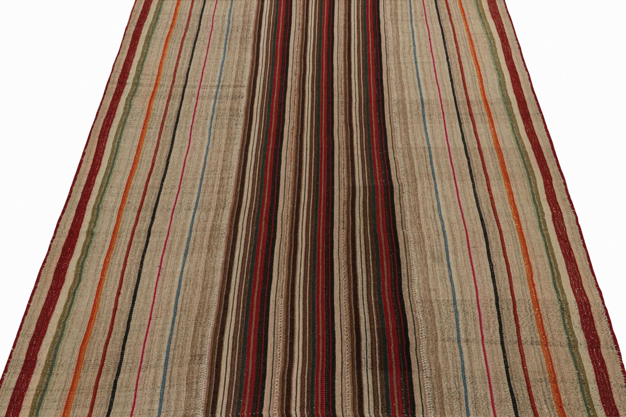This vintage 7x9 Persian Kilim is handwoven in wool, and originates circa 1950-1960.

On the Design: 

This flatweave carries striped patterns relishing a play of vibrant tones with beige-brown in panel style. It’s a comfortable choice with vast