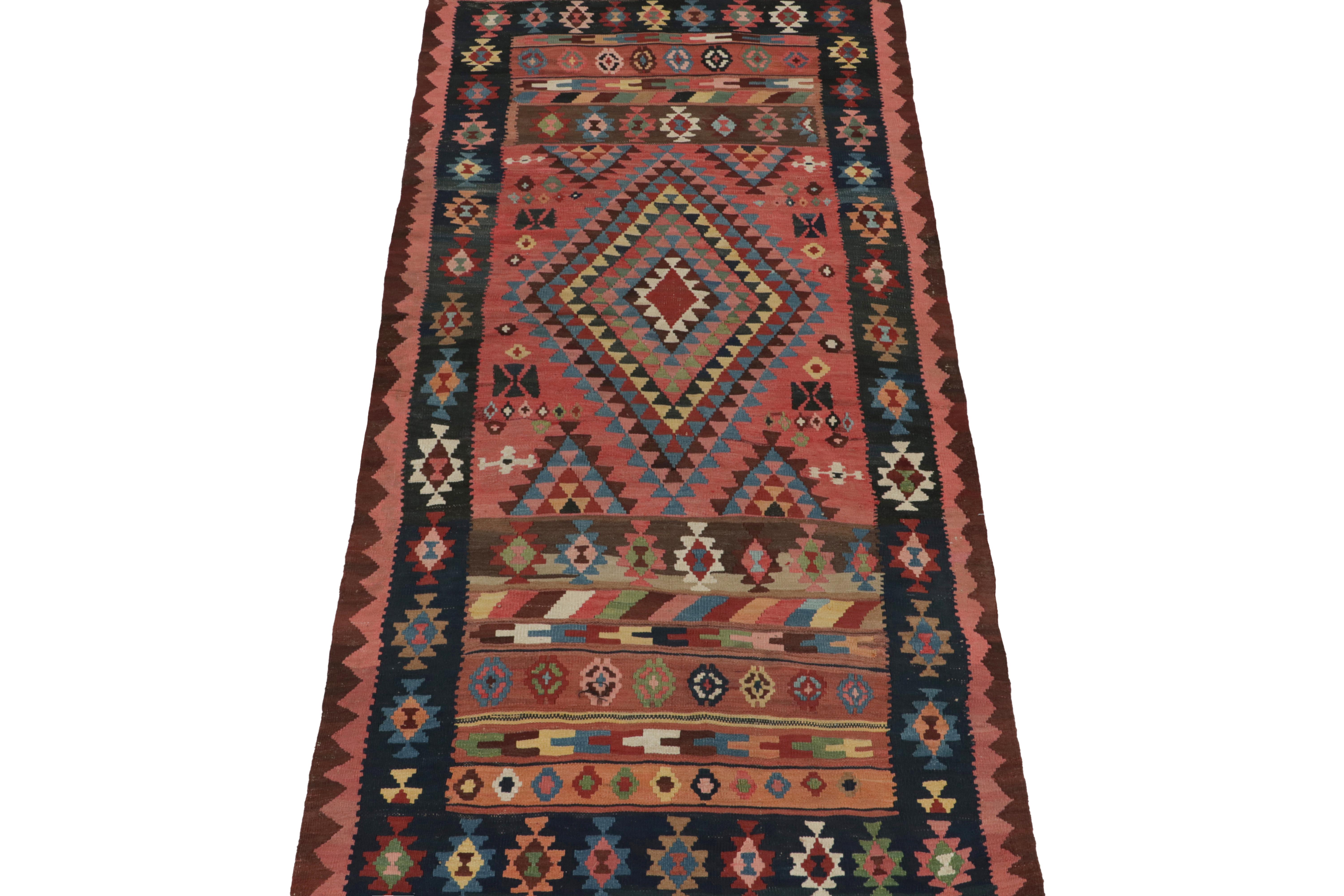 This vintage 5x10 Persian kilim is an especially rare tribal rug for its period—handwoven in wool circa 1950-1960.

Further on the Design:

The open field hosts a medallion with a rare emphasis on pale pink with orange, brown, and blue patterns