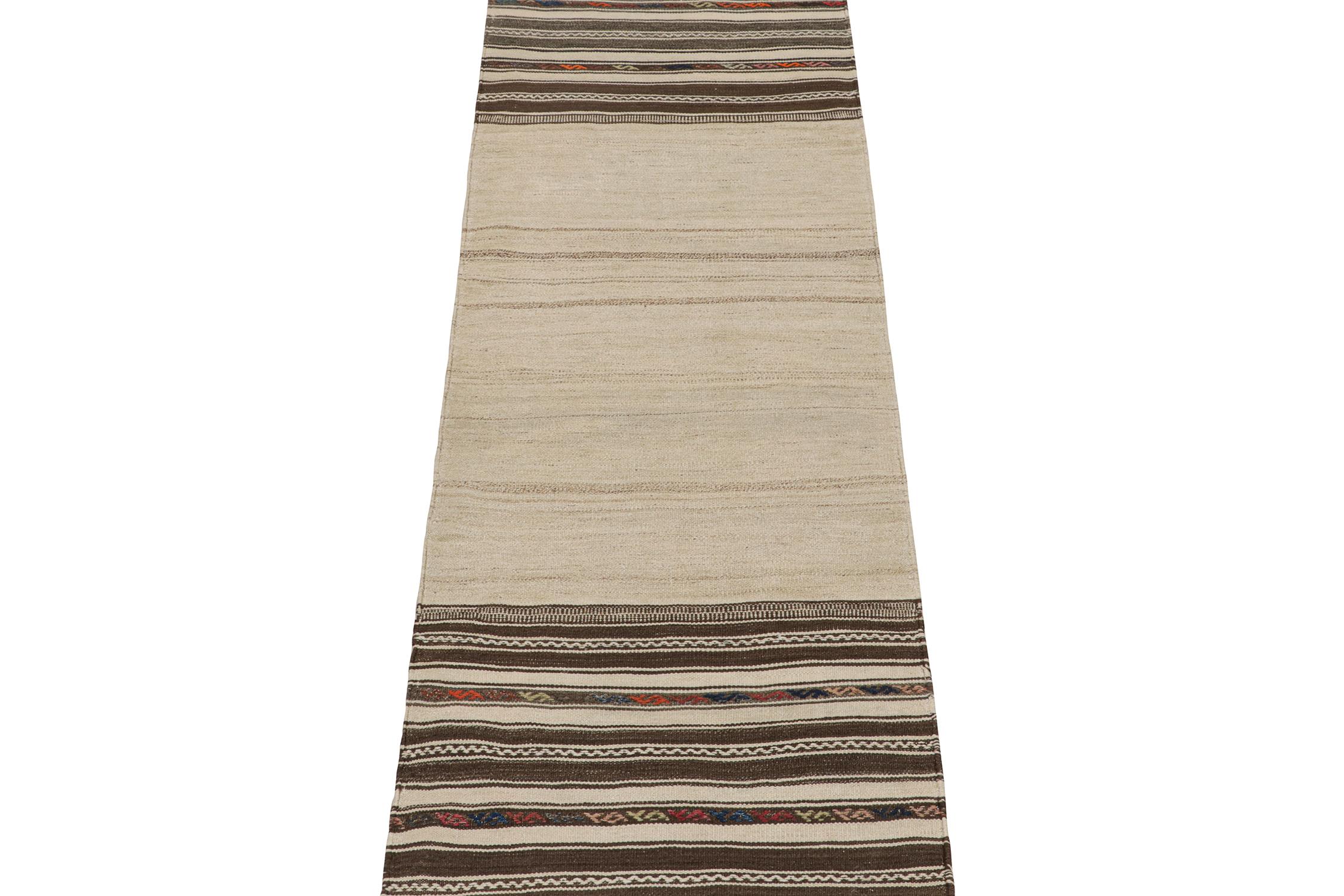 This vintage 3x10 Persian kilim is an idyllic tribal runner for its period, handwoven in wool circa 1950-1960.

Further on the Design:

A beige field unfolds to chocolate brown borders with stripes and embroidered geometric patterns from end to end.
