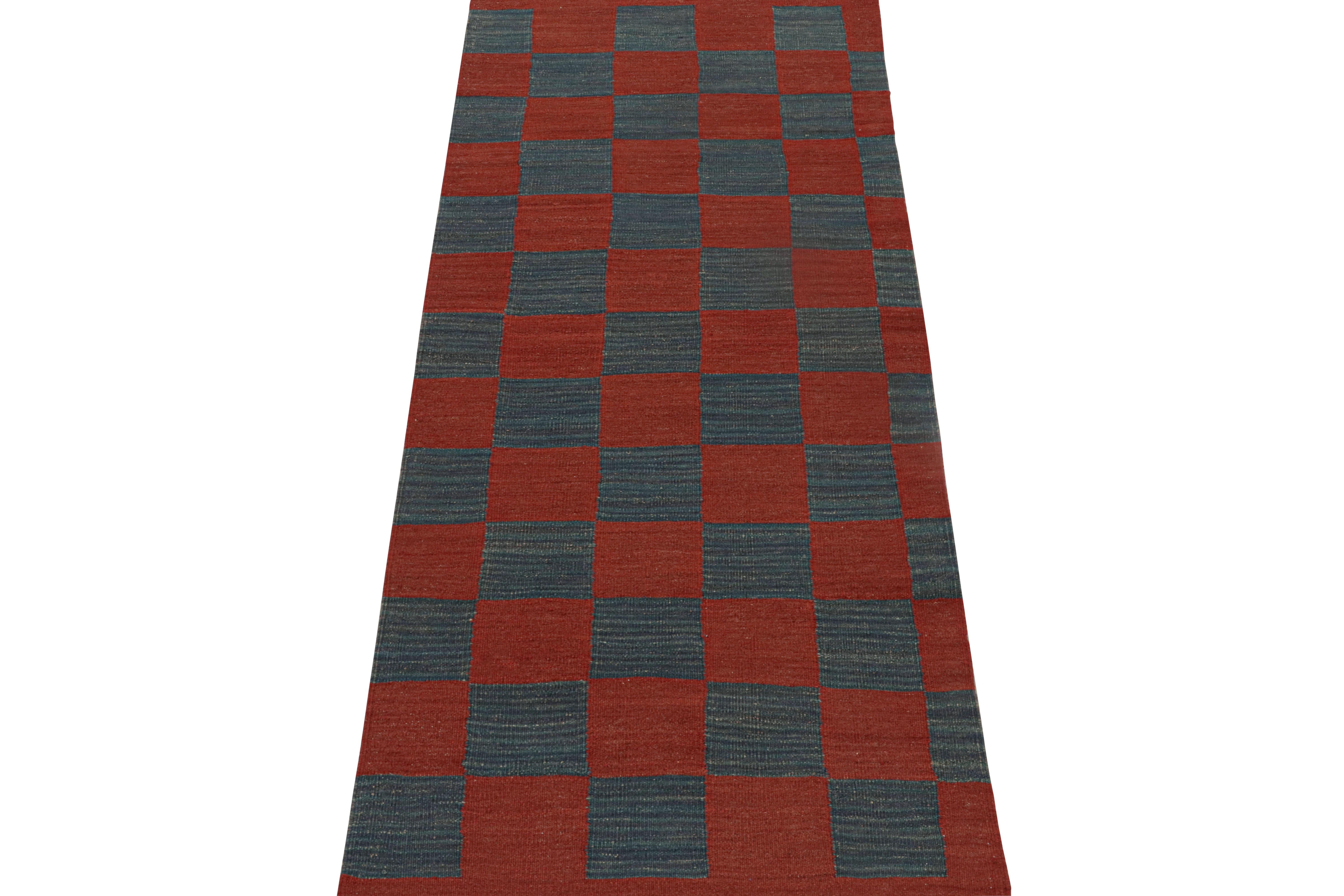 This vintage 3x8 Persian kilim is believed to be a midcentury tribal runner, handwoven in wool circa 1950-1960. 

Its design enjoys geometric patterns in a checkerboard style with rich red and navy blue colorways. The look is one of playful,