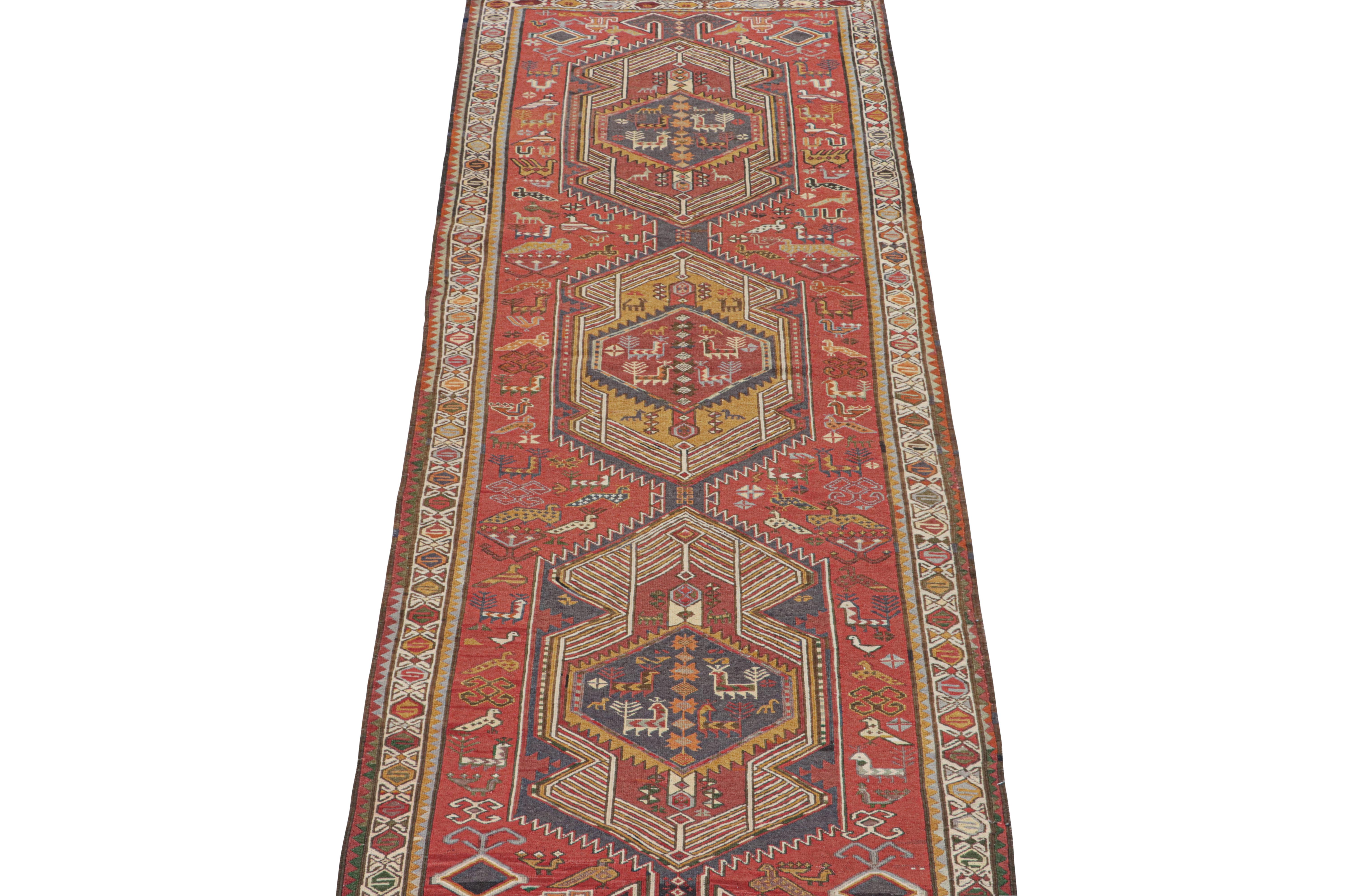 This vintage 3x9 Persian Kilim is believed to be a tribal runner of the 1950s. 

Handwoven in wool, its design plays medallion and all-over pattern style together on a bright red field. The piece further enjoys a wide range of geometric patterns