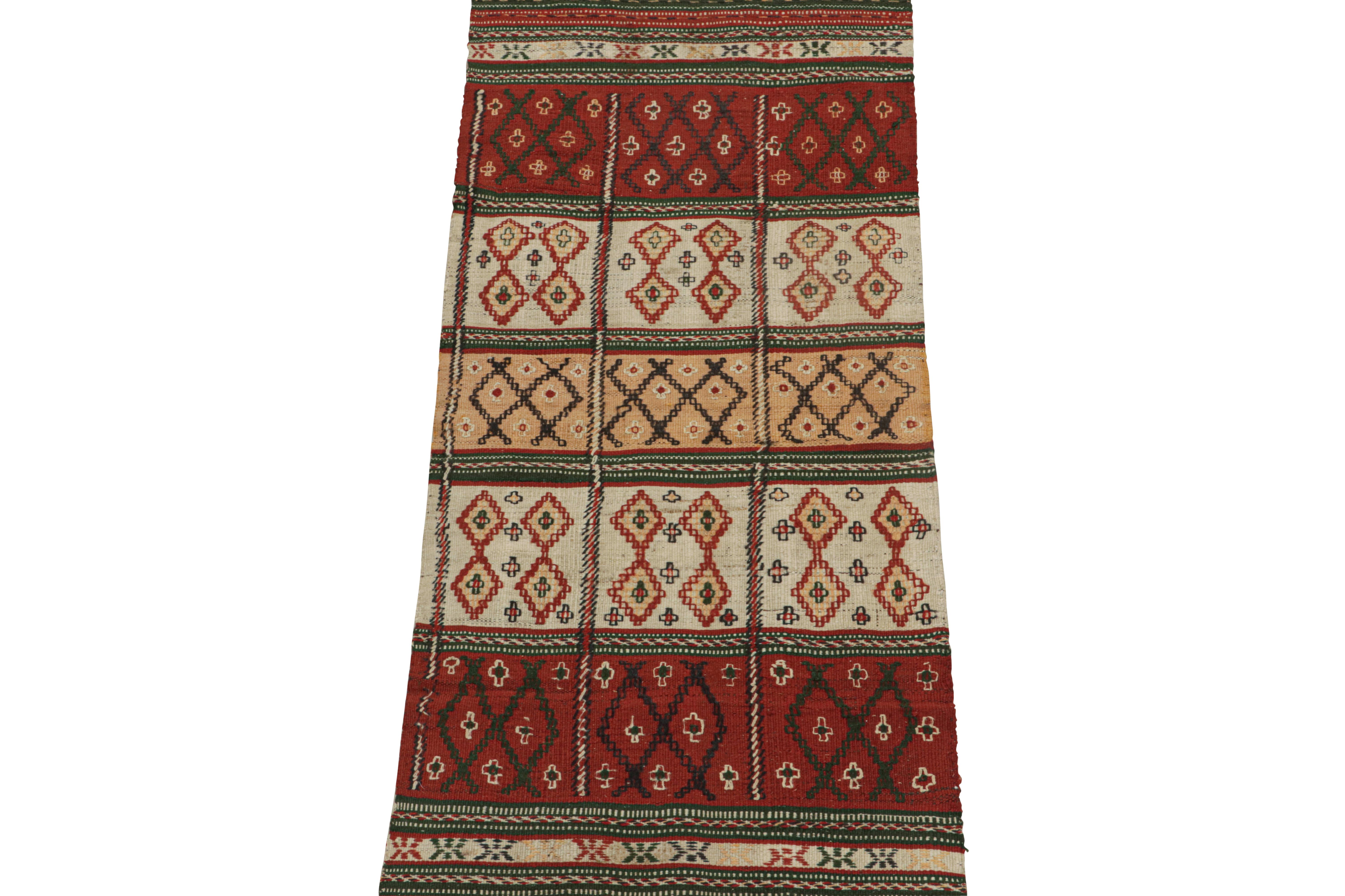 This vintage 2x6 Kilim is believed to be a tribal runner of the 1950s. 

Handwoven in wool, its design prefers geometric patterns in red, white, gold and green colorway with black accents. Keen eyes will further admire its many textural