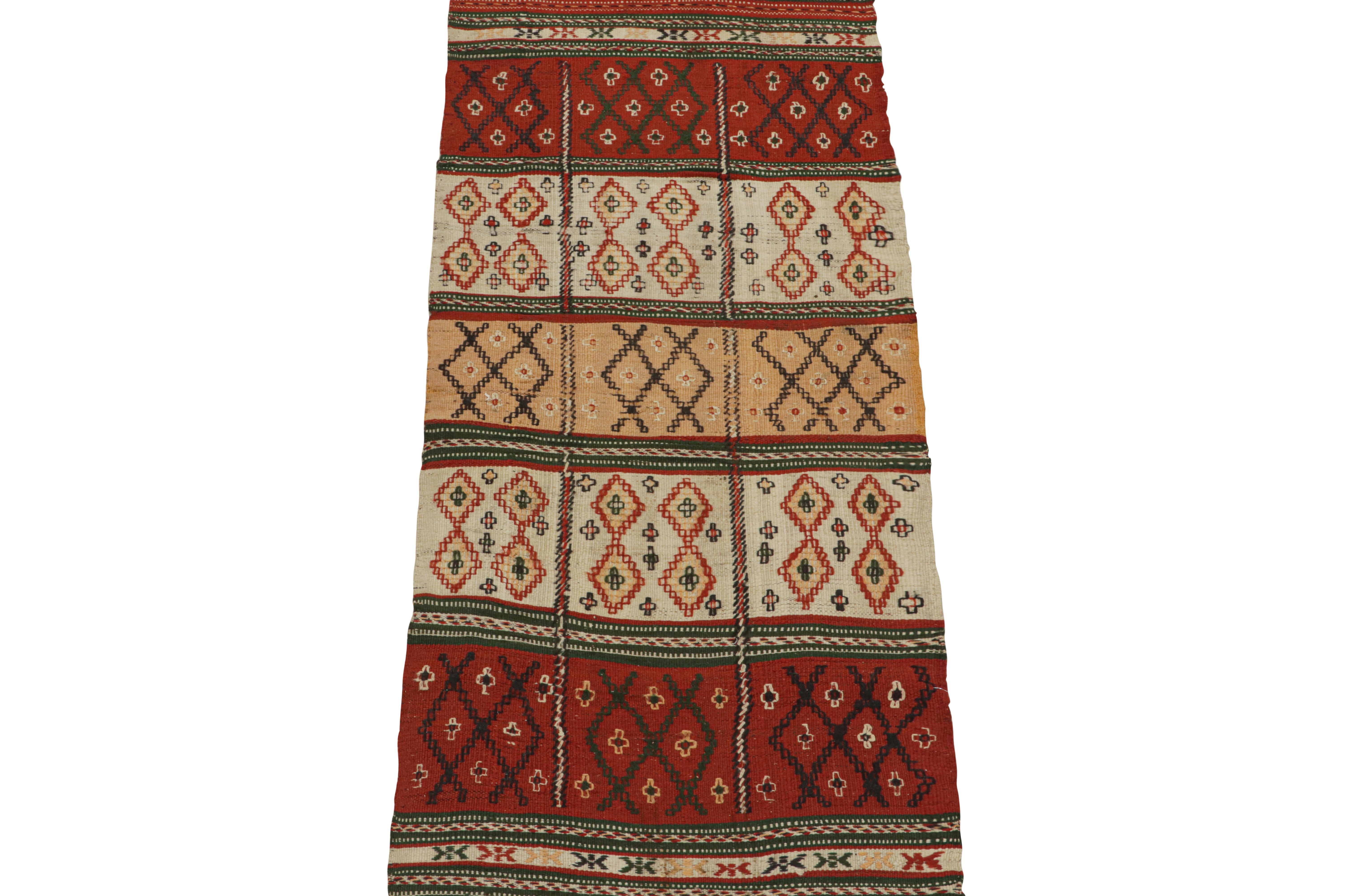 This vintage 2x6 Kilim is believed to be a tribal runner of the 1950s. 

Handwoven in wool, its design prefers geometric patterns in red, white, gold and green colorway with black accents. Keen eyes will further admire its many textural