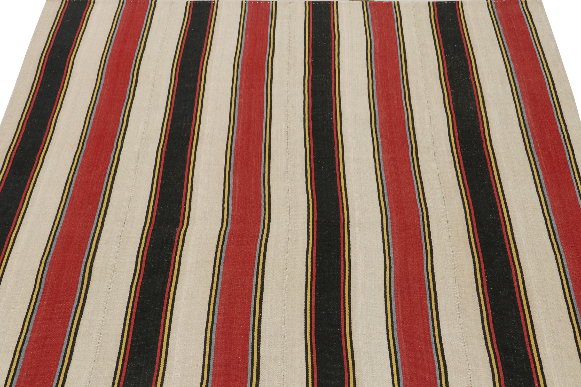 This vintage 6x7 Persian kilim is a midcentury tribal rug, handwoven in wool circa 1950-1960.

The design enjoys stripes alternating in tones of red, beige, and black with blue and yellow accents. Its technique, connoisseurs will note, is a