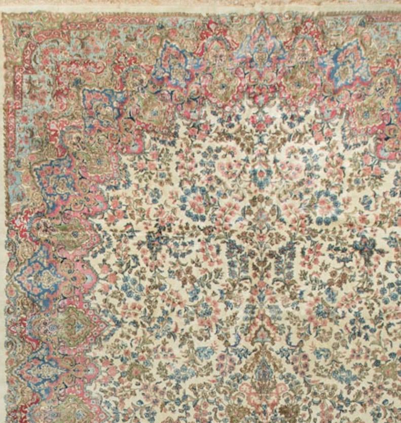 The soft ivory ground and no formal borders are very typical of Kerman rugs from this period. The soft blues and pale rose used for the floral motifs is also common in this style of Kerman and the piece works so well in a wide variety of room