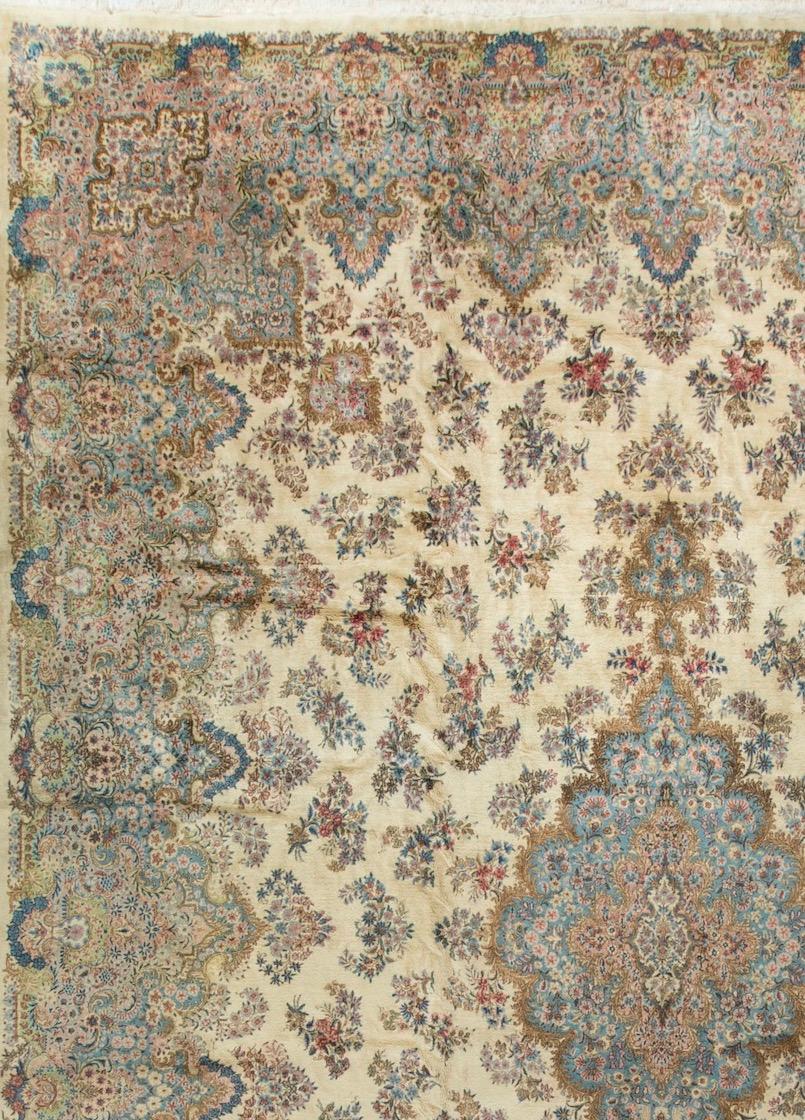 This rug has a wonderfully soft central filed, filled with floral designs surrounding a central medallion in soft blues that extends into the border to create a relaxed and gentle feel to this 1940s vintage Kirman from central Persia. Measures: