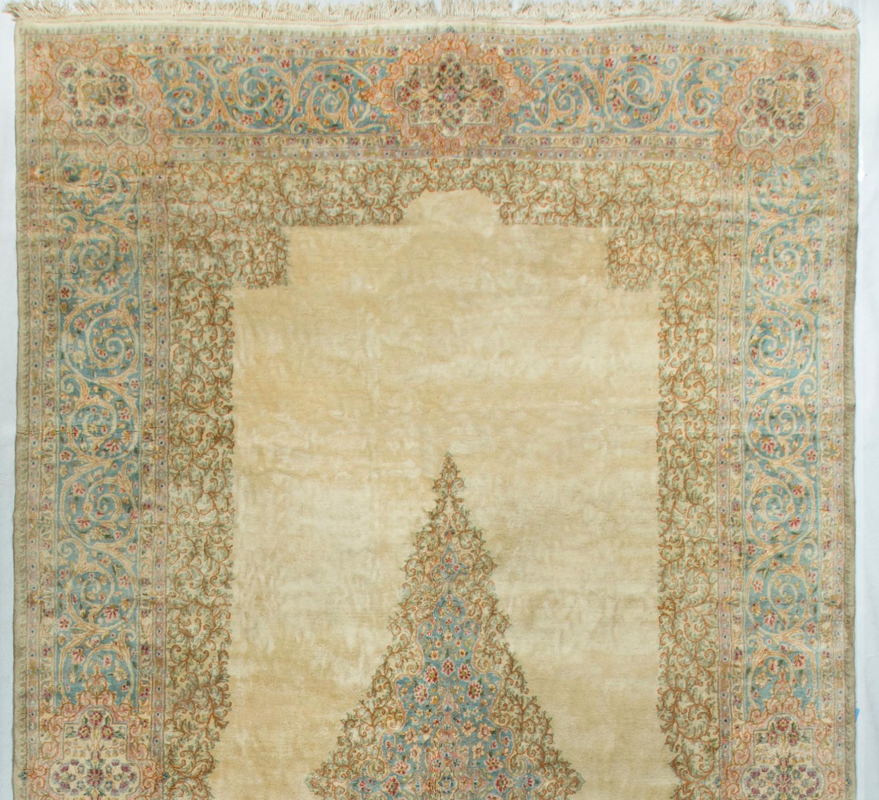 This wonderful vintage rug has an easygoing and subdued feel created by the central ivory ground enclosing a softly blue colored central medallion. All is surrounded by multiple borders, the main soft blue border repeating the medallion theme.