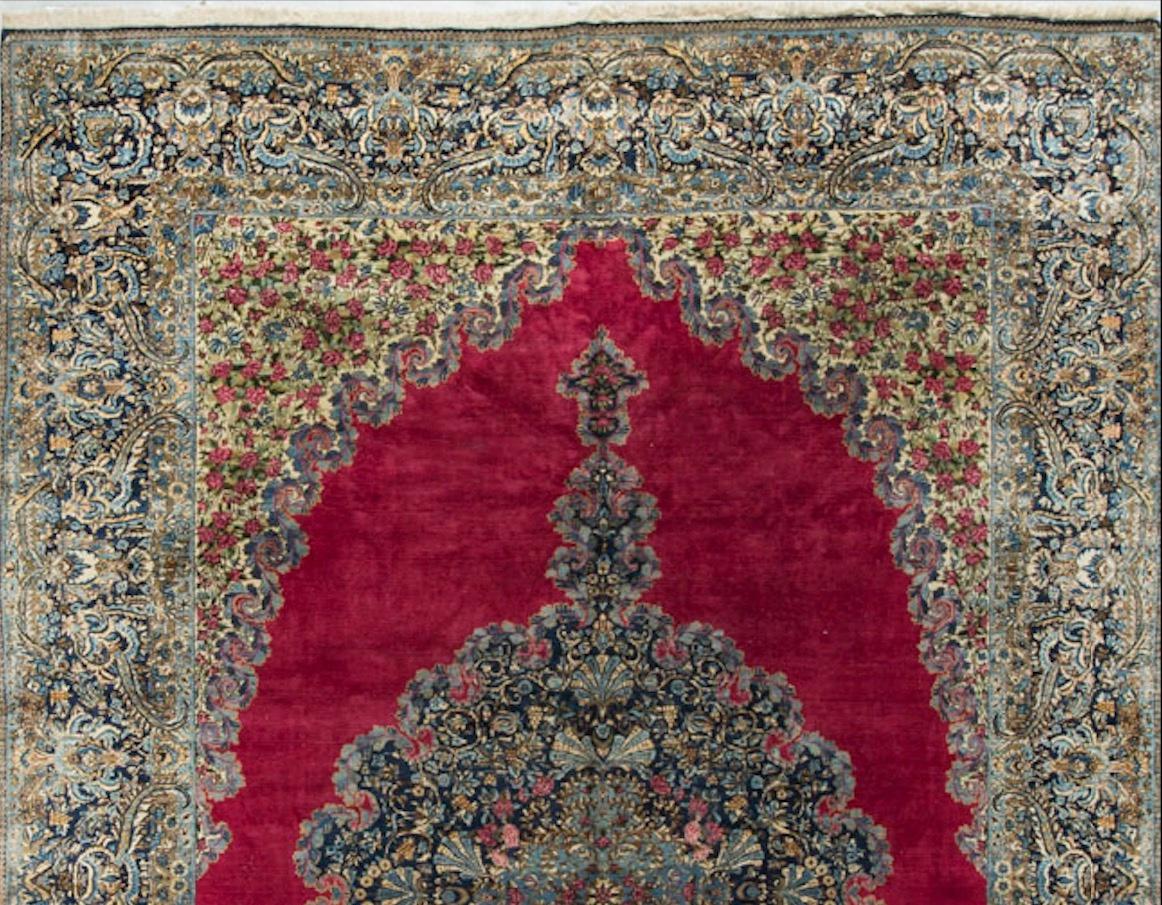 The central medallion filled with flowers sits on a wonderful crimson field, with floral spandrels in the corners. The border in blue is also filled with floral motifs. Measures: 10'8