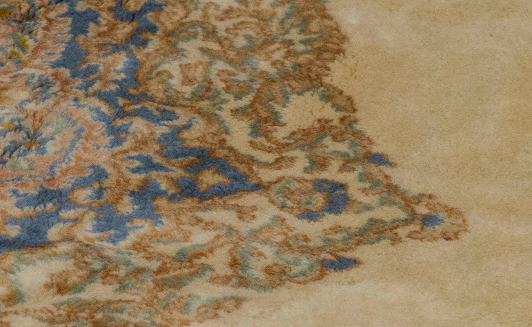 Ein reizvoller Kerman-Teppich, der mit exquisiten Details gewebt wurde. Der rote Grund ist mit gewebten Blumenmustern gefüllt, die ein zentrales elfenbeinfarbenes und zartblaues Medaillon umgeben, das von einer zartgrünen Hauptbordüre und