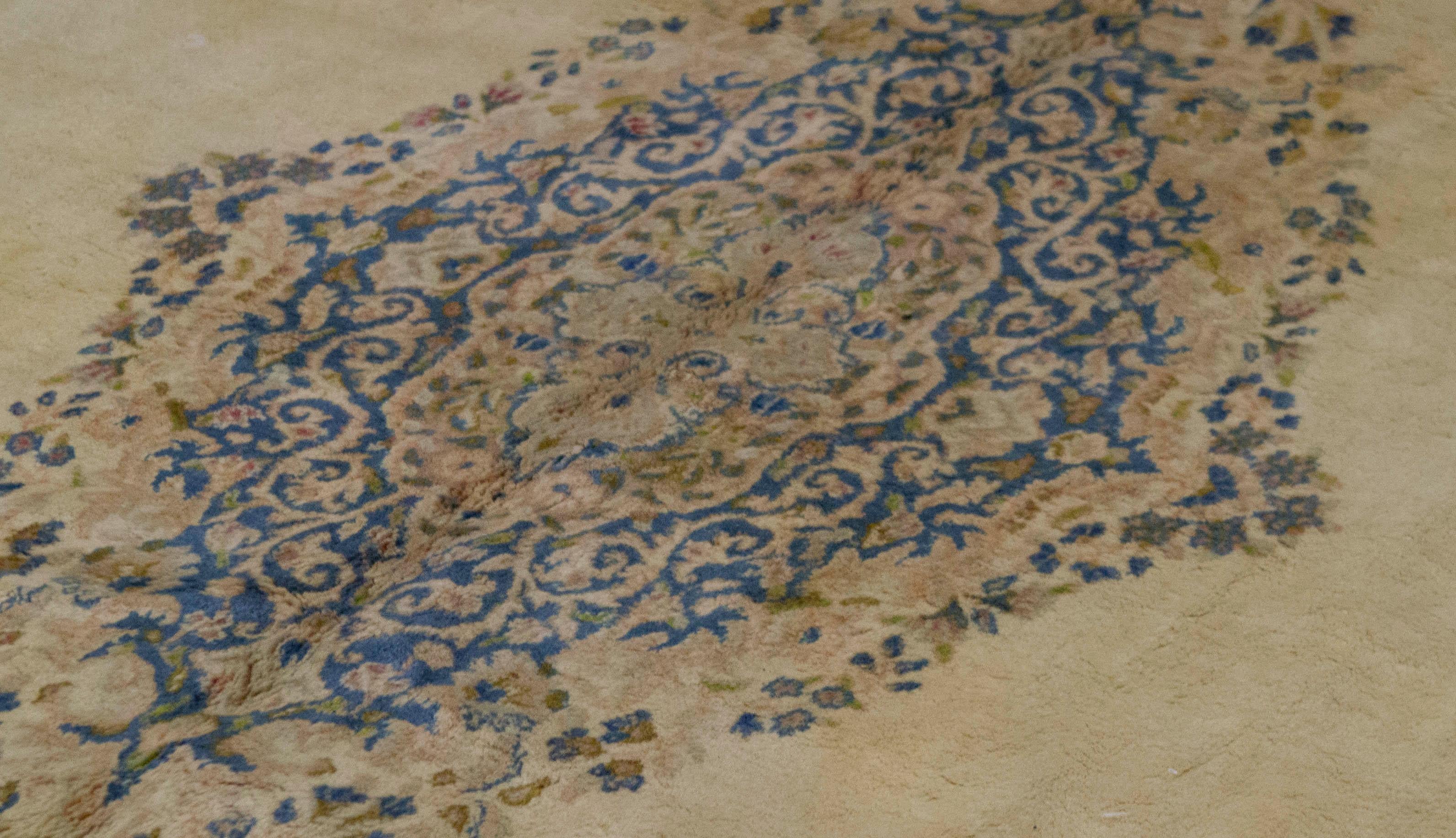 Ein reizvoller Kerman-Teppich, der mit exquisiten Details gewebt wurde. Der rote Grund ist mit gewebten Blumenmustern gefüllt, die ein zentrales elfenbeinfarbenes und zartblaues Medaillon umgeben, das von einer zartgrünen Hauptbordüre und