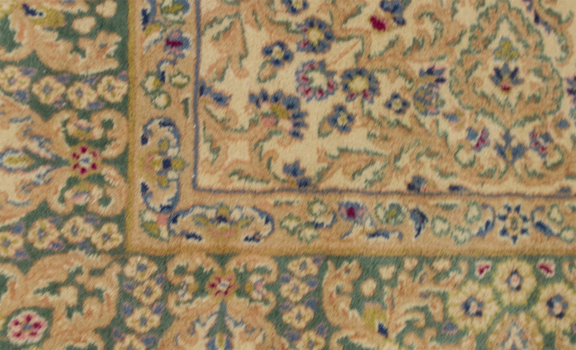 Ein reizvoller Kerman-Teppich, der mit exquisiten Details gewebt wurde. Der rote Grund ist mit gewebten Blumenmustern gefüllt, die ein zentrales elfenbeinfarbenes und zartblaues Medaillon umgeben, das von einer zartgrünen Hauptbordüre und