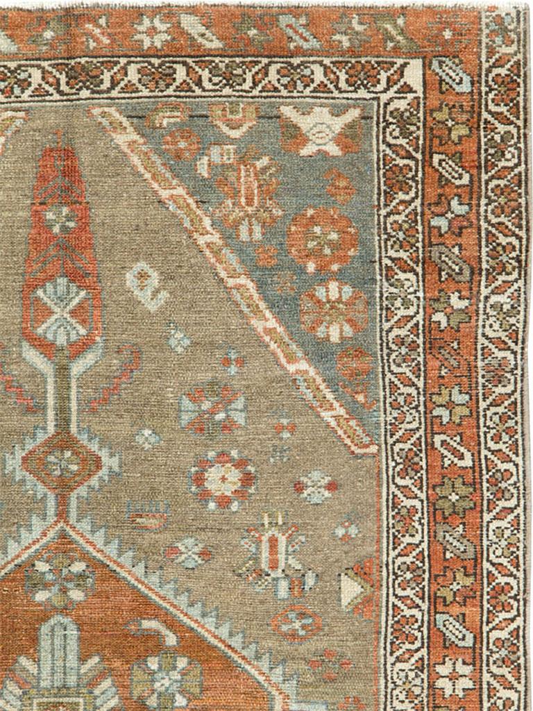 A vintage Persian Kurdish rug from the mid-20th century. A burnt orange hexagonal medallion with a very fragmented Herati inner pattern shows bold, tall cypress tree pendants, all on the light brown field displaying disjoint rosettes, with en suite