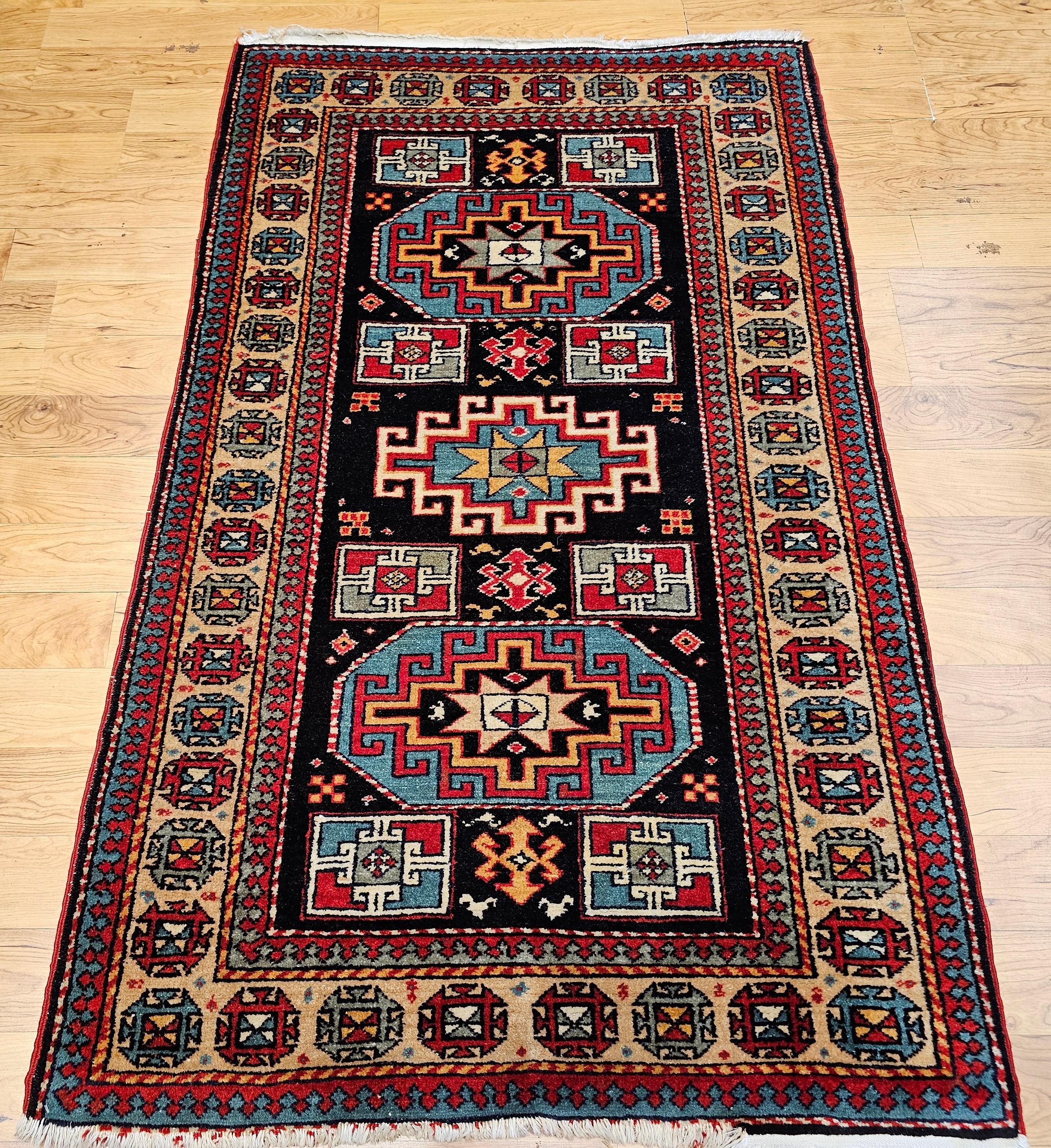 Dieser außergewöhnliche persisch-kurdische Teppich aus der Mitte des 20. Jahrhunderts zeichnet sich durch ein auffälliges geometrisches Medaillonmuster aus, das an kaukasische Kazak-Webereien aus dem 19. Jahrhundert erinnert. Das detailreiche Feld