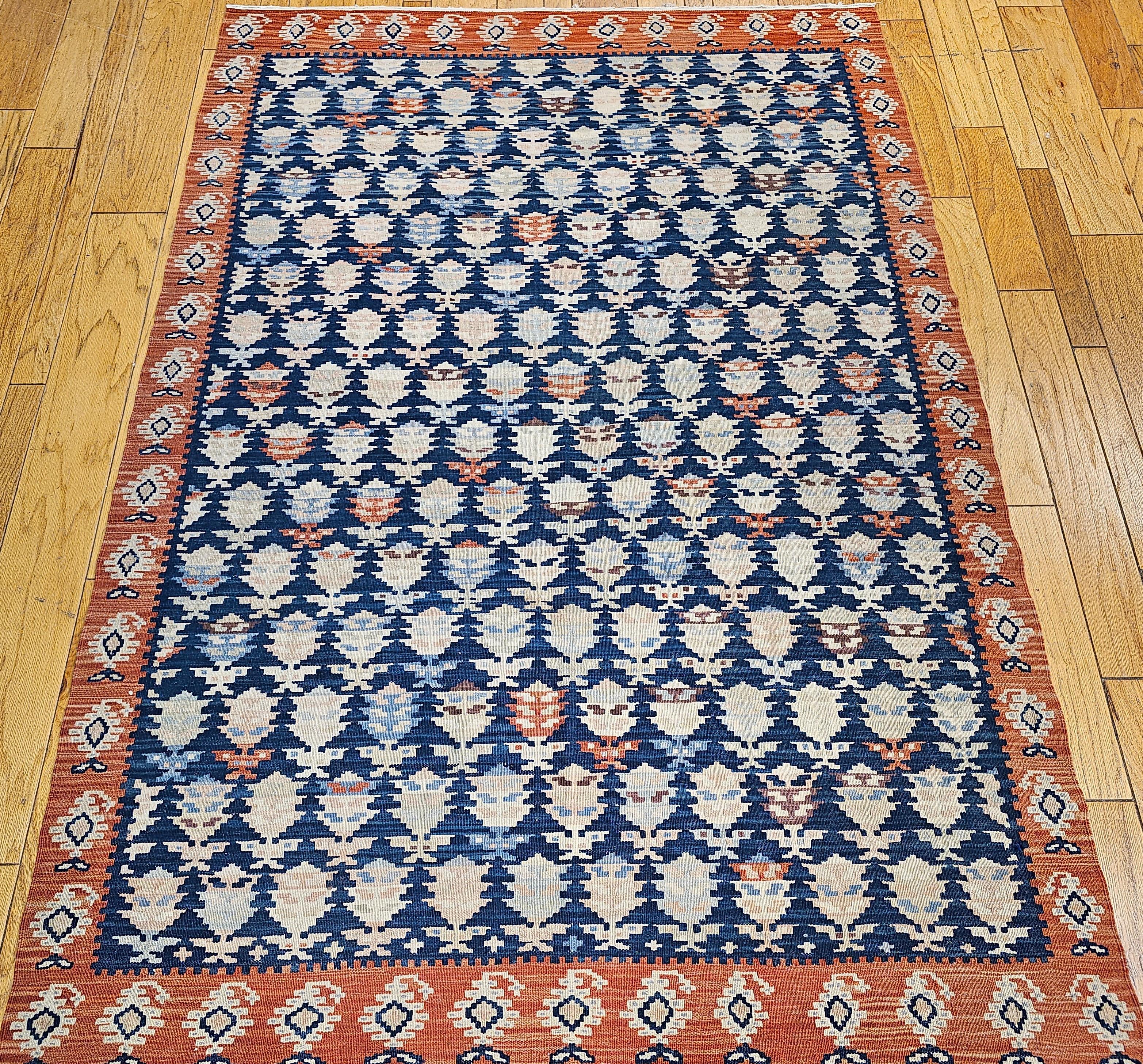 Vintage hand-woven room size Persian Kurdish Kilim in an all-over paisley pattern. The Kurdish kilim has an abrash French blue background with paisley designs in ivory, red, and pink changing directions from one row to another. The border is