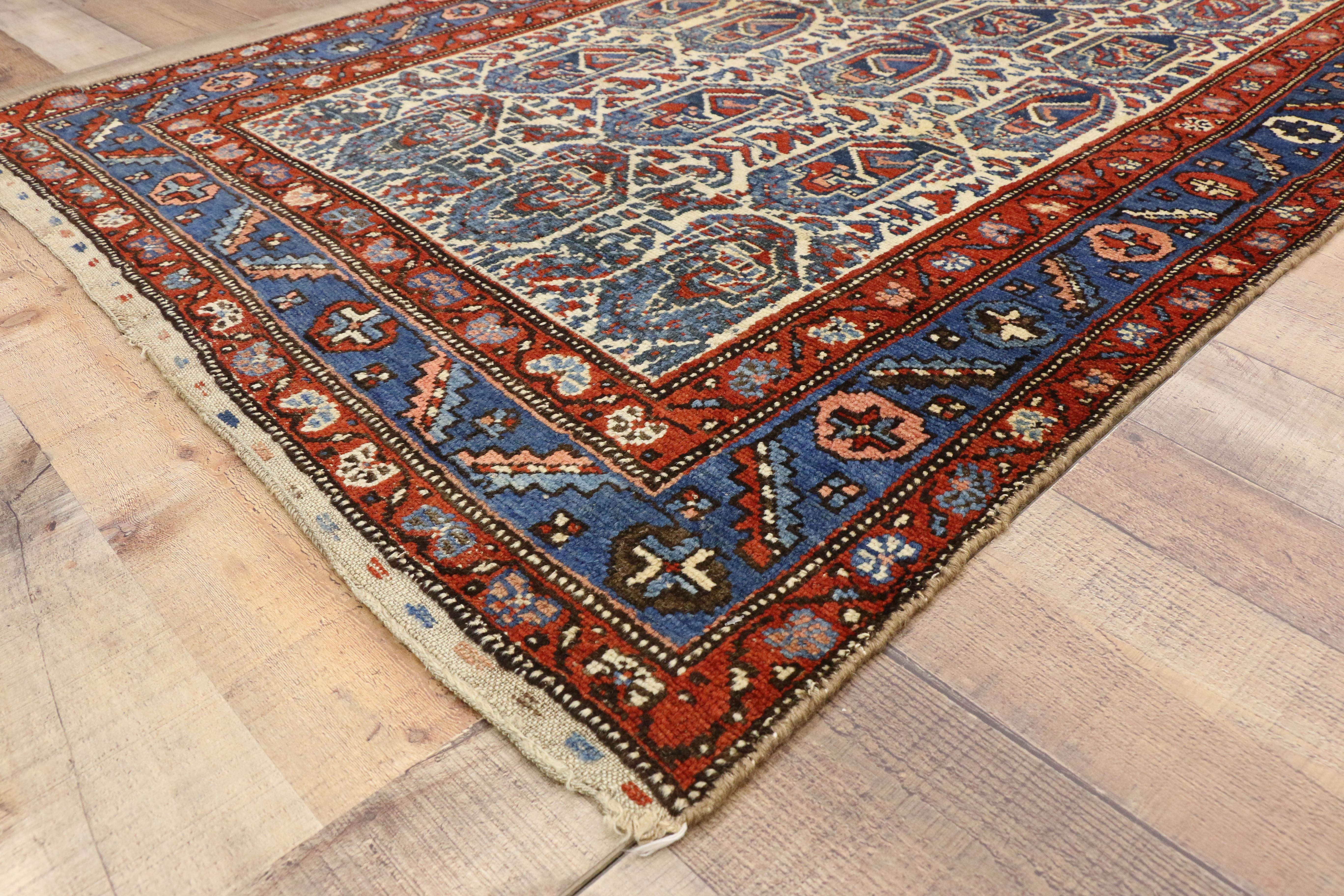 71867, vintage Kurd rug with Blue Boteh pattern. This hand knotted wool vintage Persian Kurd rug with Blue Boteh pattern is a stunning example of Kurdish weaving. Blue botehs also known as paisleys cover the white center field. Set with angular red