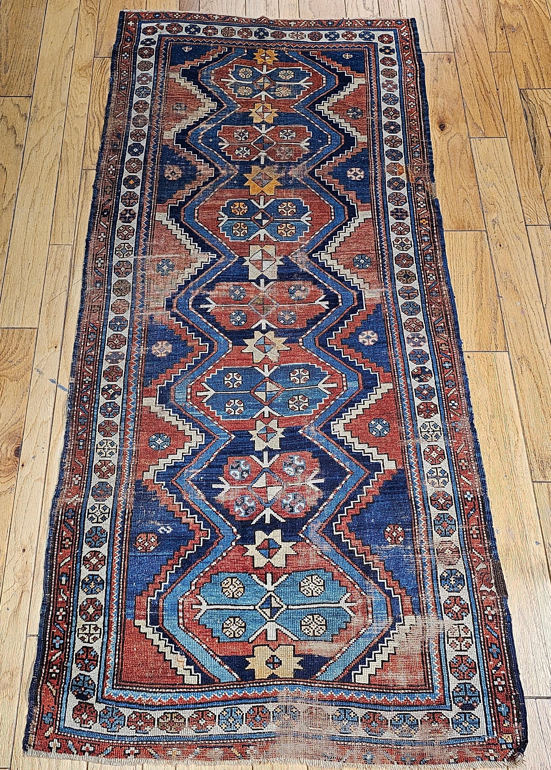 Vintage Persian Kurdish tribal area rug/wide runner circa die frühen 1900er Jahre.  Der schöne und farbenfrohe kurdische Teppich hat ein geometrisches Muster mit sieben kleinen Medaillons in einer einzigen Säule im Hauptfeld, das in Blau- und