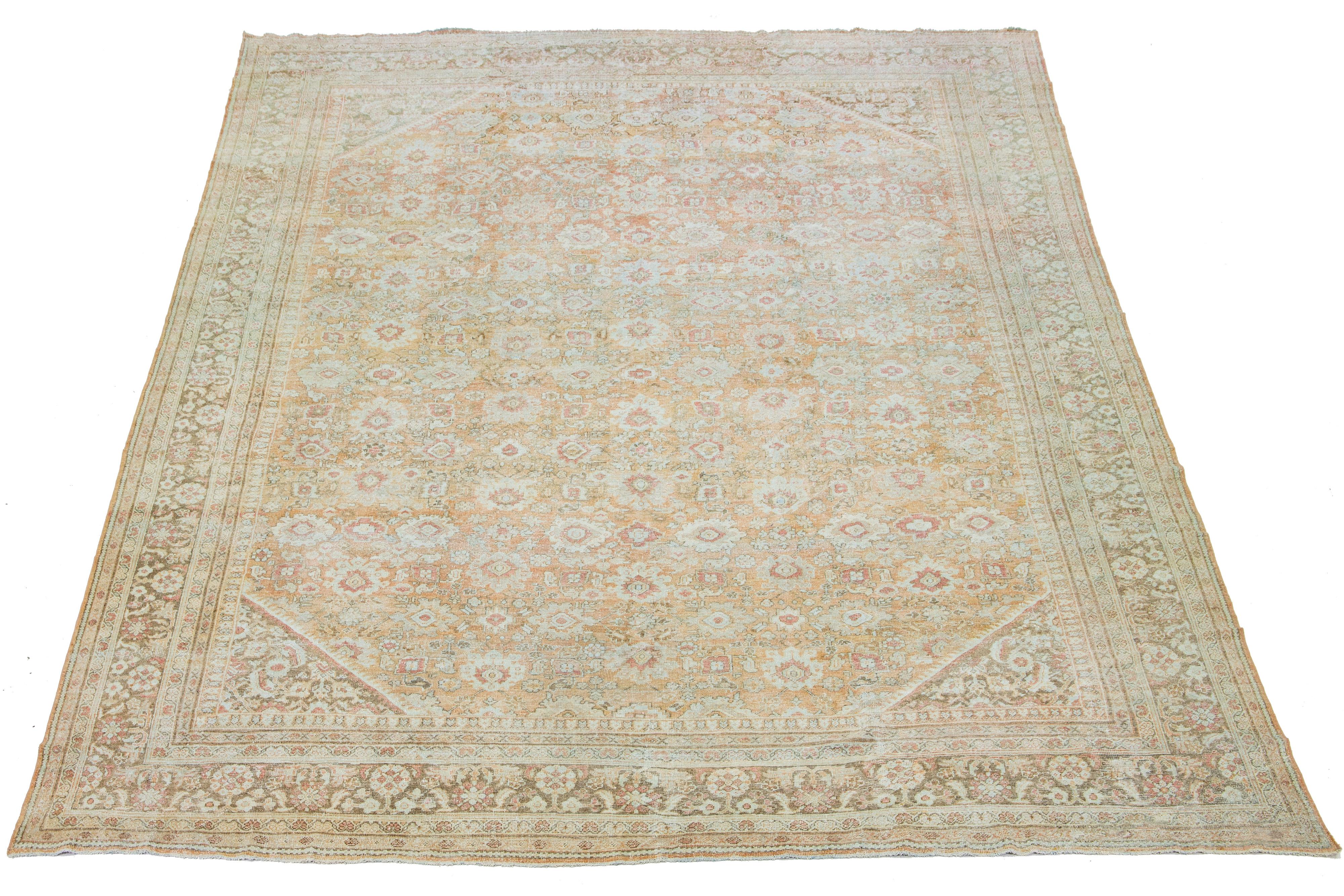 Beautiful vintage hand-knotted Mahal wool rug with an orange-peach field. It features blue, red, and ivory accents in an all-over floral design.

This rug measures 12'4