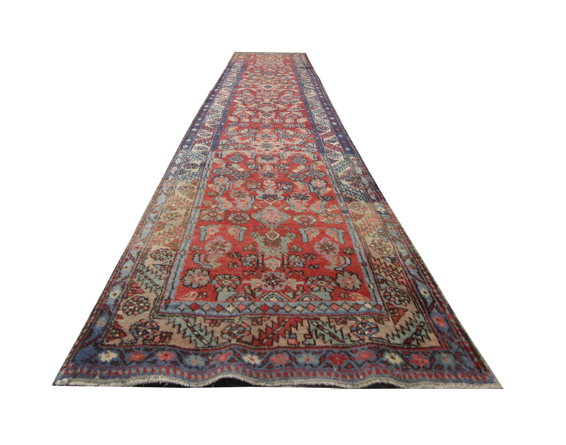 This long runner rug is perfect for a modern or traditional interior. On a background of deep red, various coloured motifs sit intertwining colours of Green Blue and Pink, to create a Symmetrical pattern. The border is predominantly blue with