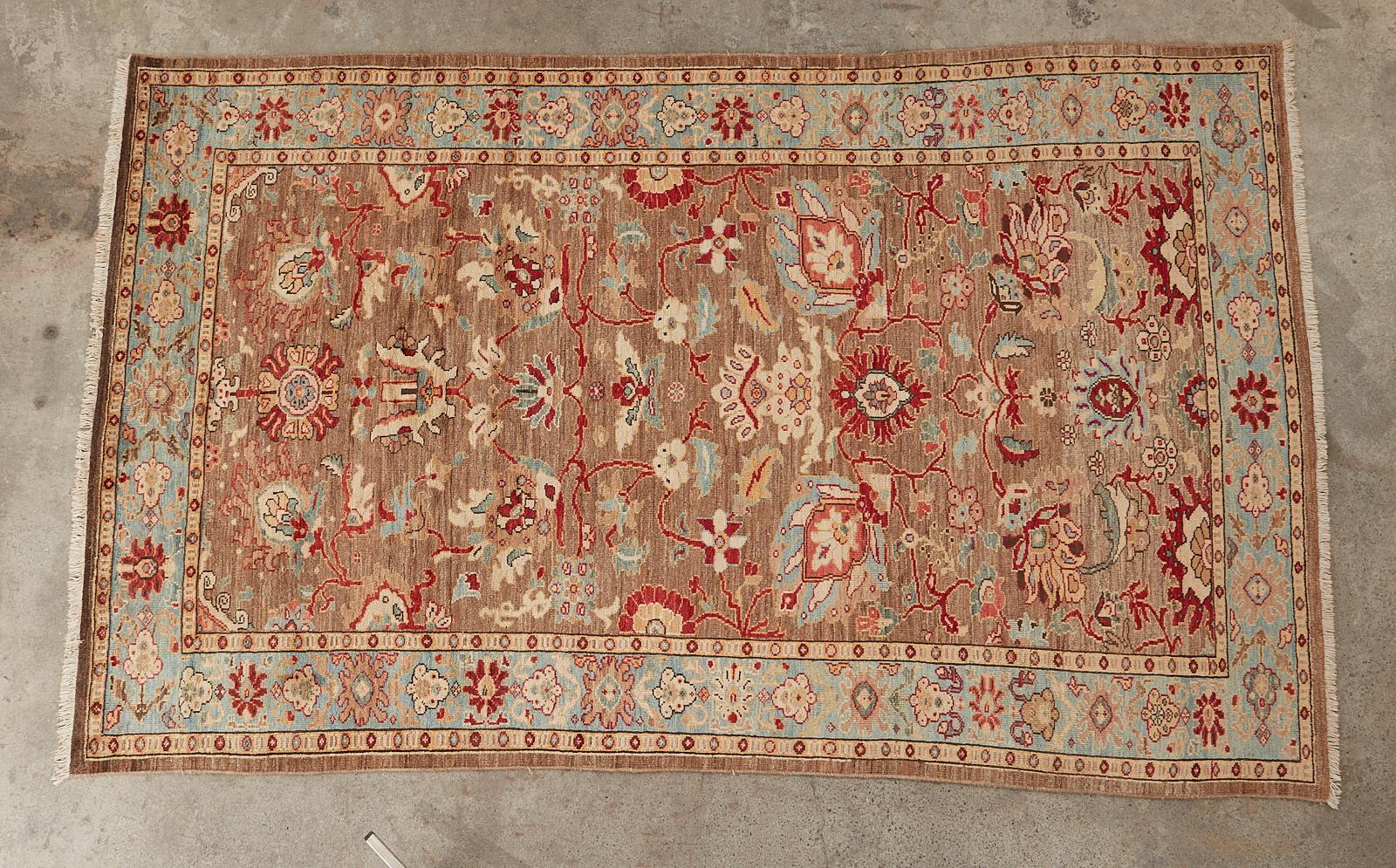 Gorgeous Persian Mahal Style hand-knotted wool rug featuring jewel toned colors. The carpet is decorated with large, whimsical flower heads over a dark beige field, which makes the light blues and ruby reds boldly stand out. From an estate in San