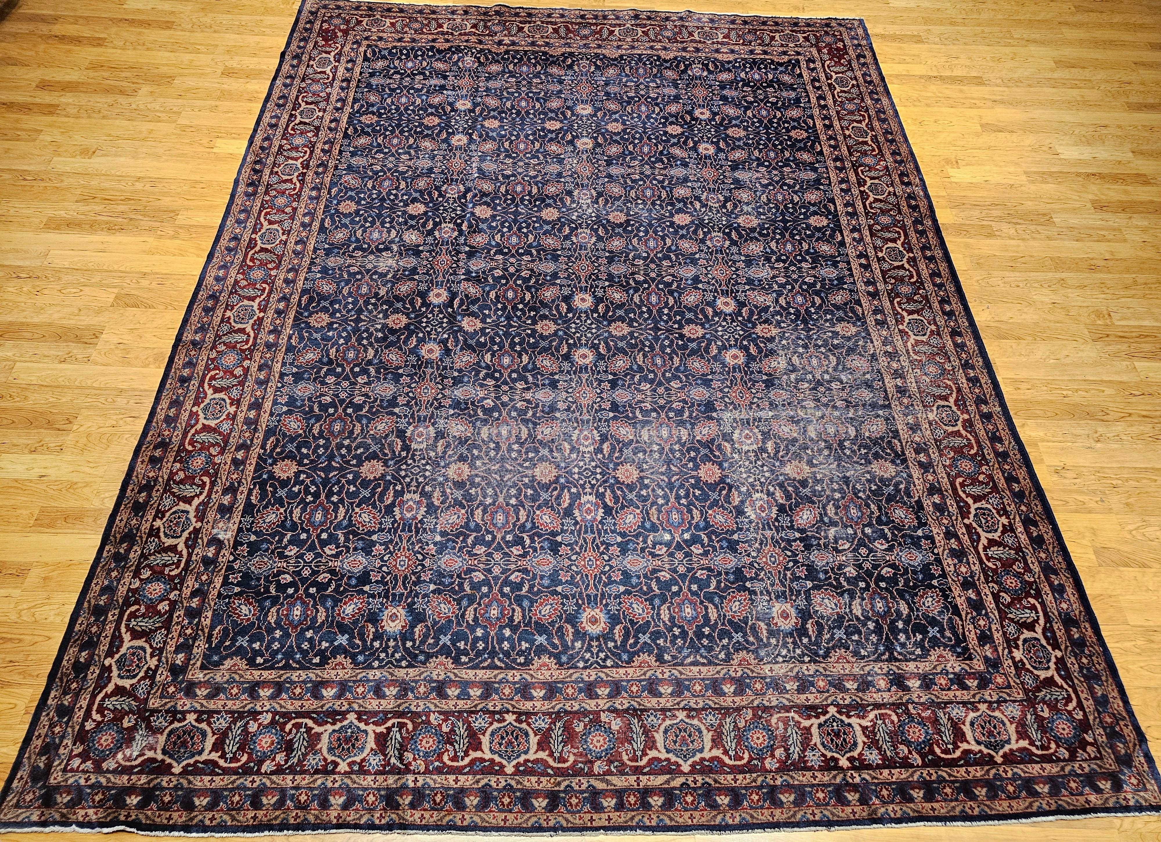 Beautiful oversized Persian Mahal Sultanabad carpet from the first quarter of the 1900s is in an allover design pattern.  The primary field color is dark blue with a dark burgundy border.  It has an allover pattern consisting of small medallions and