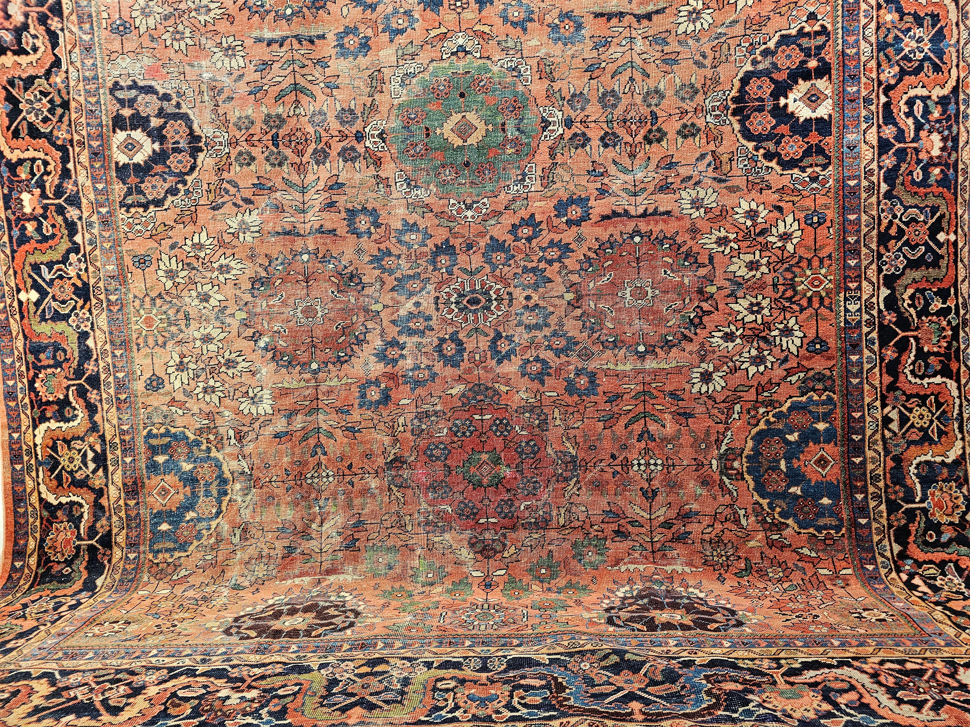 Beautiful Persian Mahal Sultanabad room size rug with an all over design pattern in a brick red field color with medallions in green, French blue, burgundy, apricot, and brown colors from the late 1800s.   The rug has a rust-red field color with