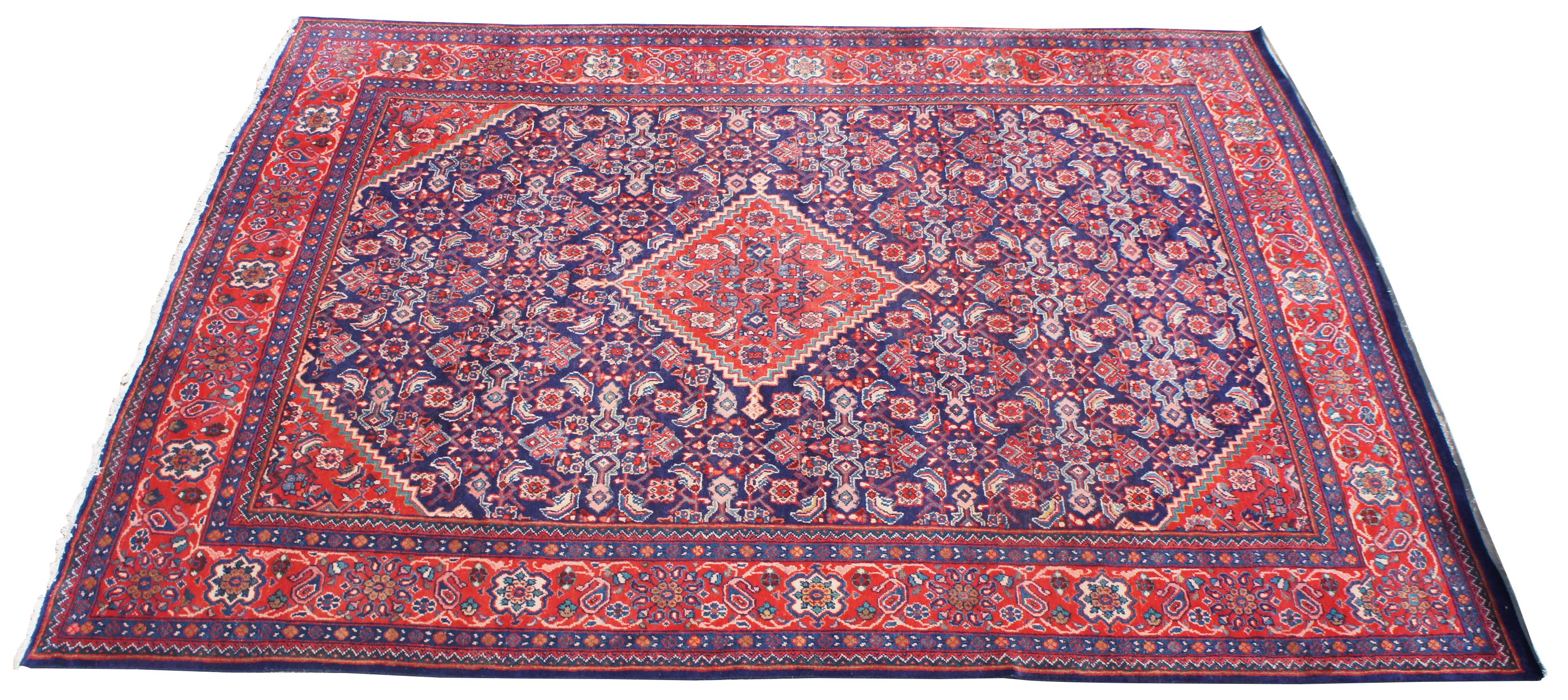 This hand knotted wool vintage Persian / Iranian Mahal rug featuring a stepped lozenge amulet medallion surrounded by an all-over pattern composed of lattice, florals, and palmettes. Complementary colored spandrels with comb edges grace each corner.