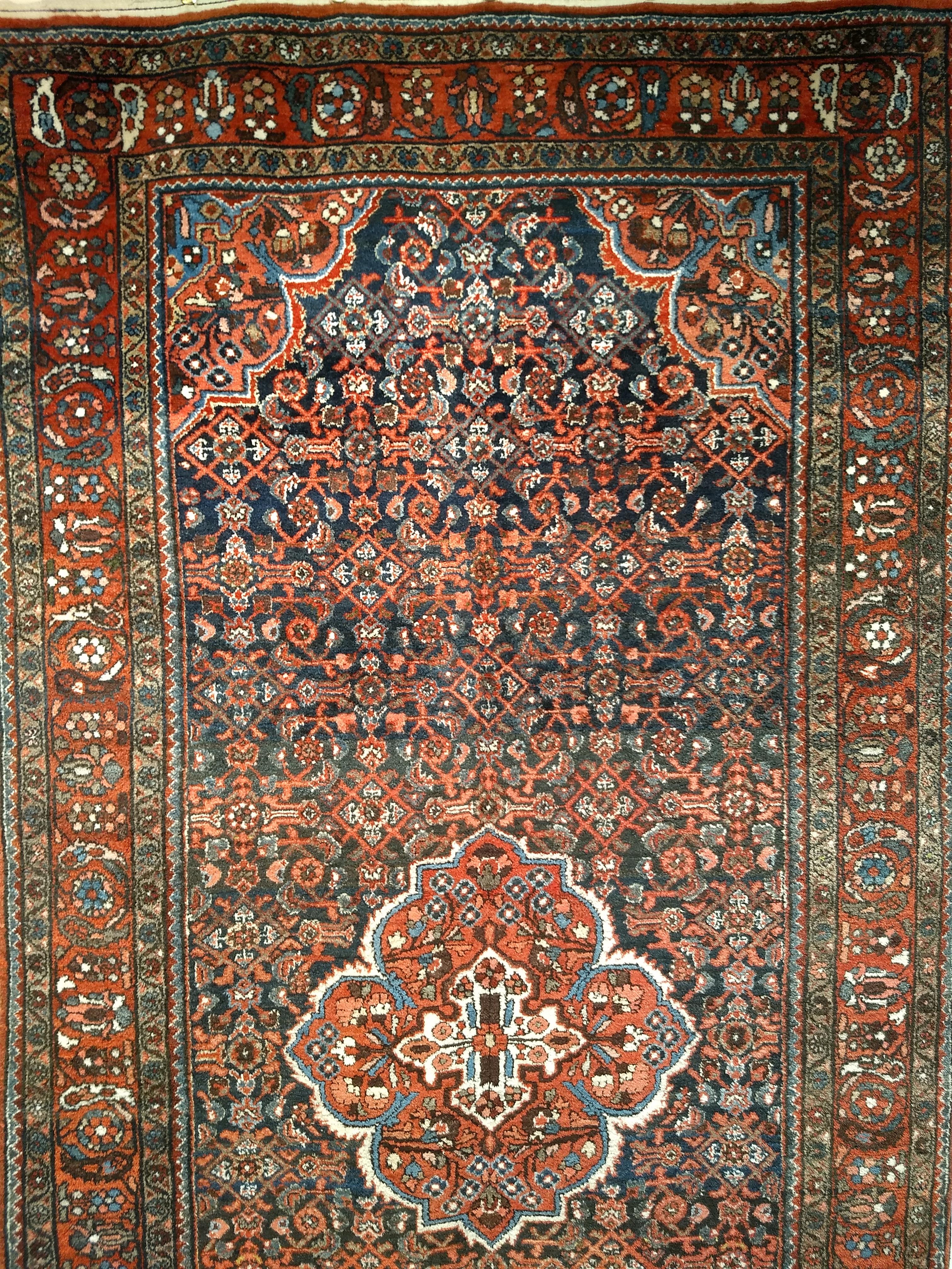 Beautiful vintage Persian Malayer area rug in Herati allover design with a small central medallion.  The background field color is in an abrash navy blue color.  The Malayer rug has  a rust red color border which is a wonderful combination. The