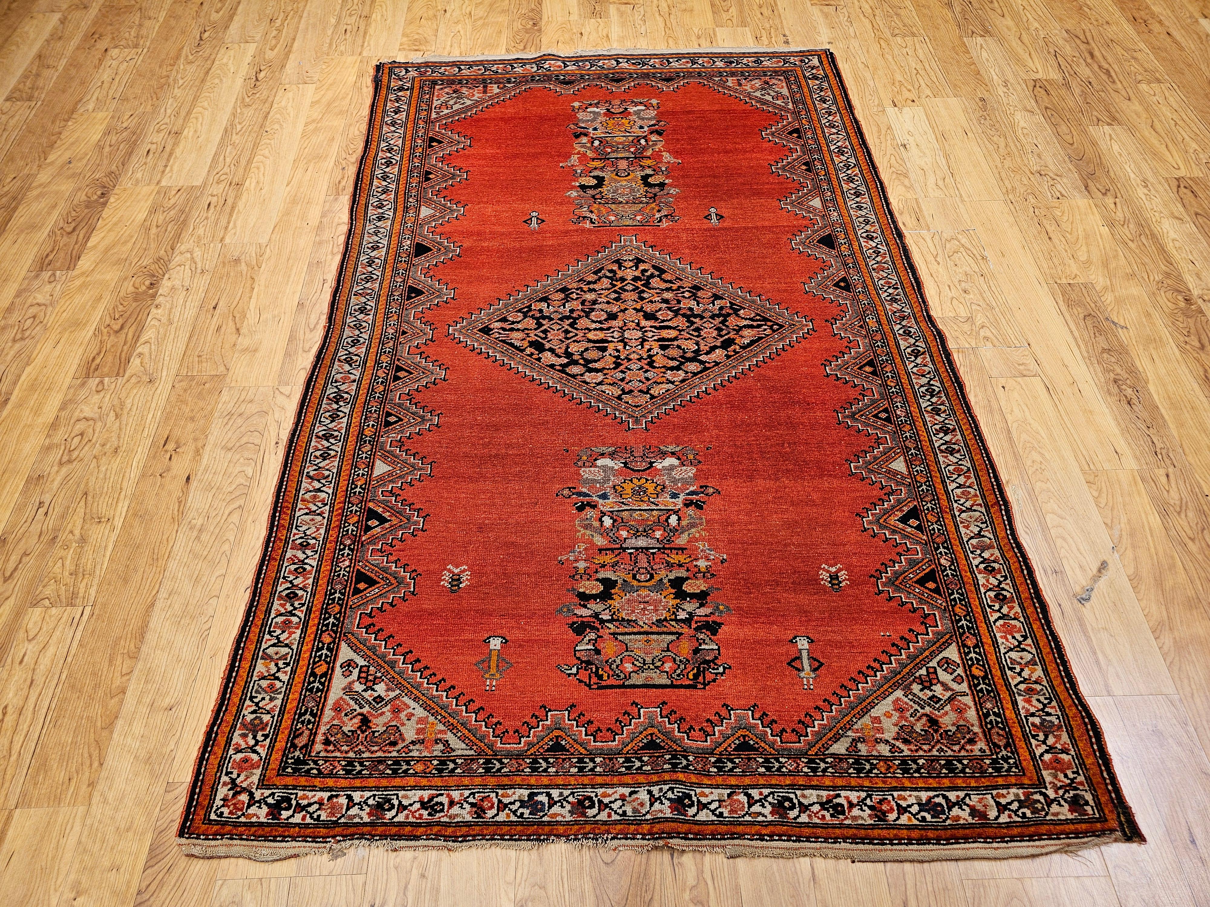 This exquisite vintage Persian Malayer area rug, handwoven in the early 20th century (circa 1900–1925), is a rare and elegant example of traditional Persian artistry. The rug features a beautifully restrained, open-field design set against a warm