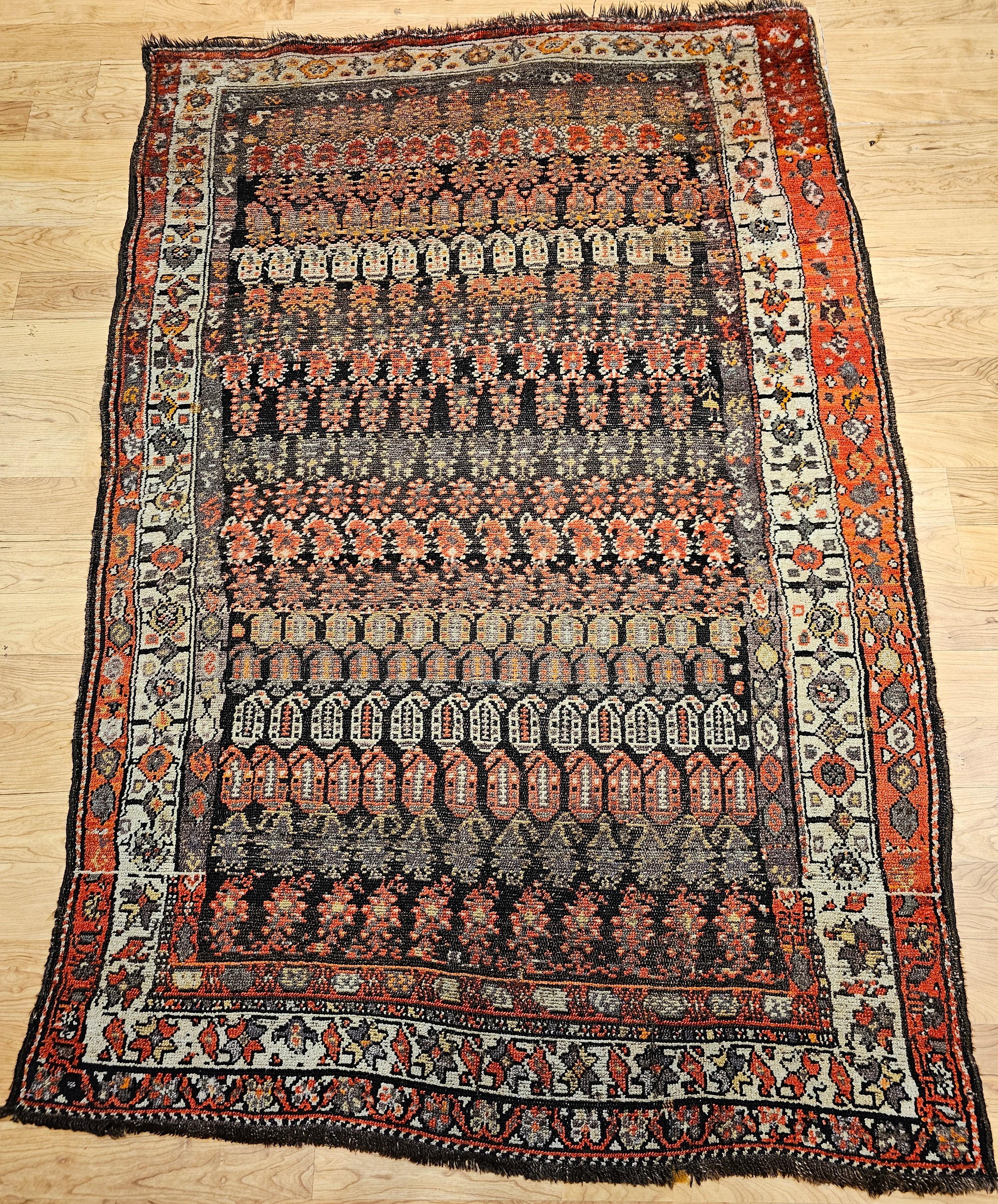 This vintage hand-knotted Persian Malayer rug features a captivating allover paisley pattern, a classic symbol of Persian artistry and heritage. Set against a richly toned abrash brown-black background, the rug displays rows of paisley motifs in