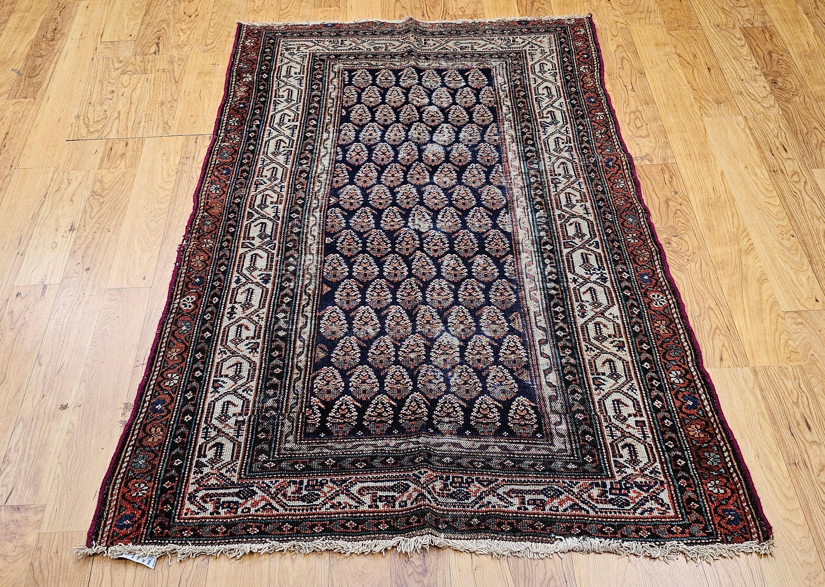 Cet exquis tapis persan Malayer, tissé au début du XXe siècle, présente un motif cachemire raffiné sur un riche fond bleu marine. Les tapis Malayer sont réputés pour leur art et leurs détails complexes, et cette pièce illustre cette tradition avec