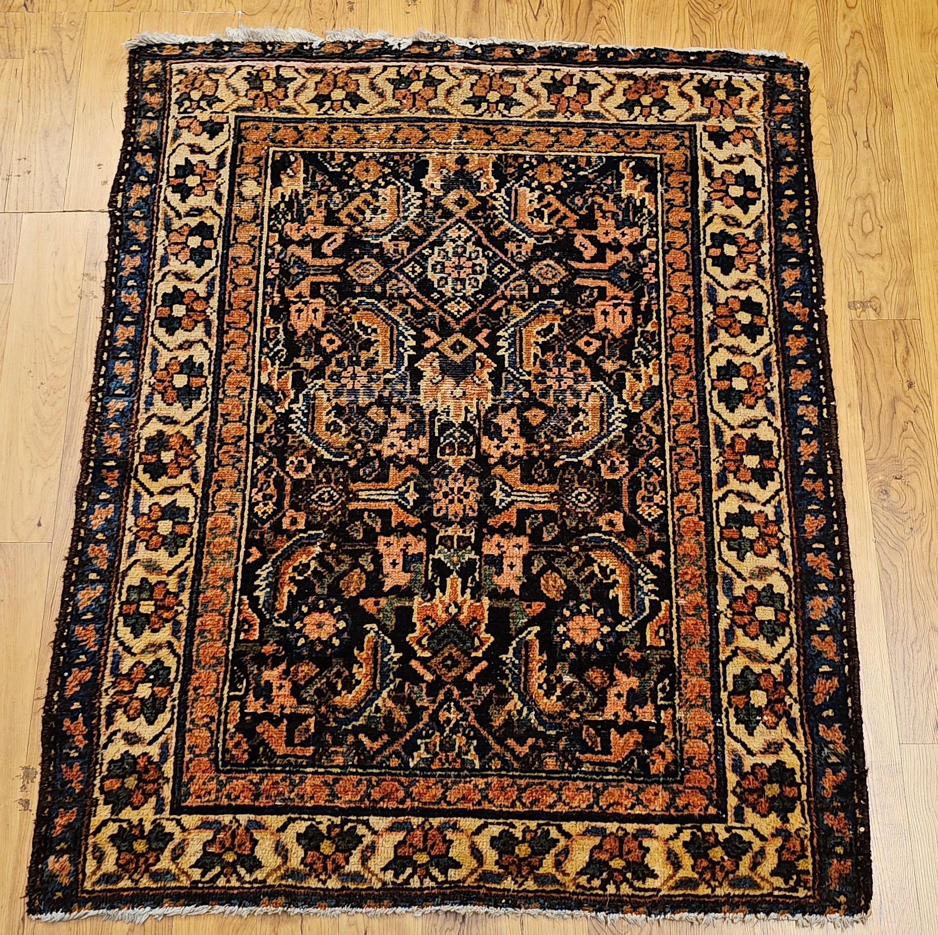 Dieser antike persische Malayer-Teppich, gewebt in den frühen 1900er Jahren, zeigt das klassische Herati-Allover-Muster in einem tiefen marineblauen Feld. Die fein gezeichneten Motive sind in Grün-, Rosa-, Blau- und Rostrot-Tönen gehalten und