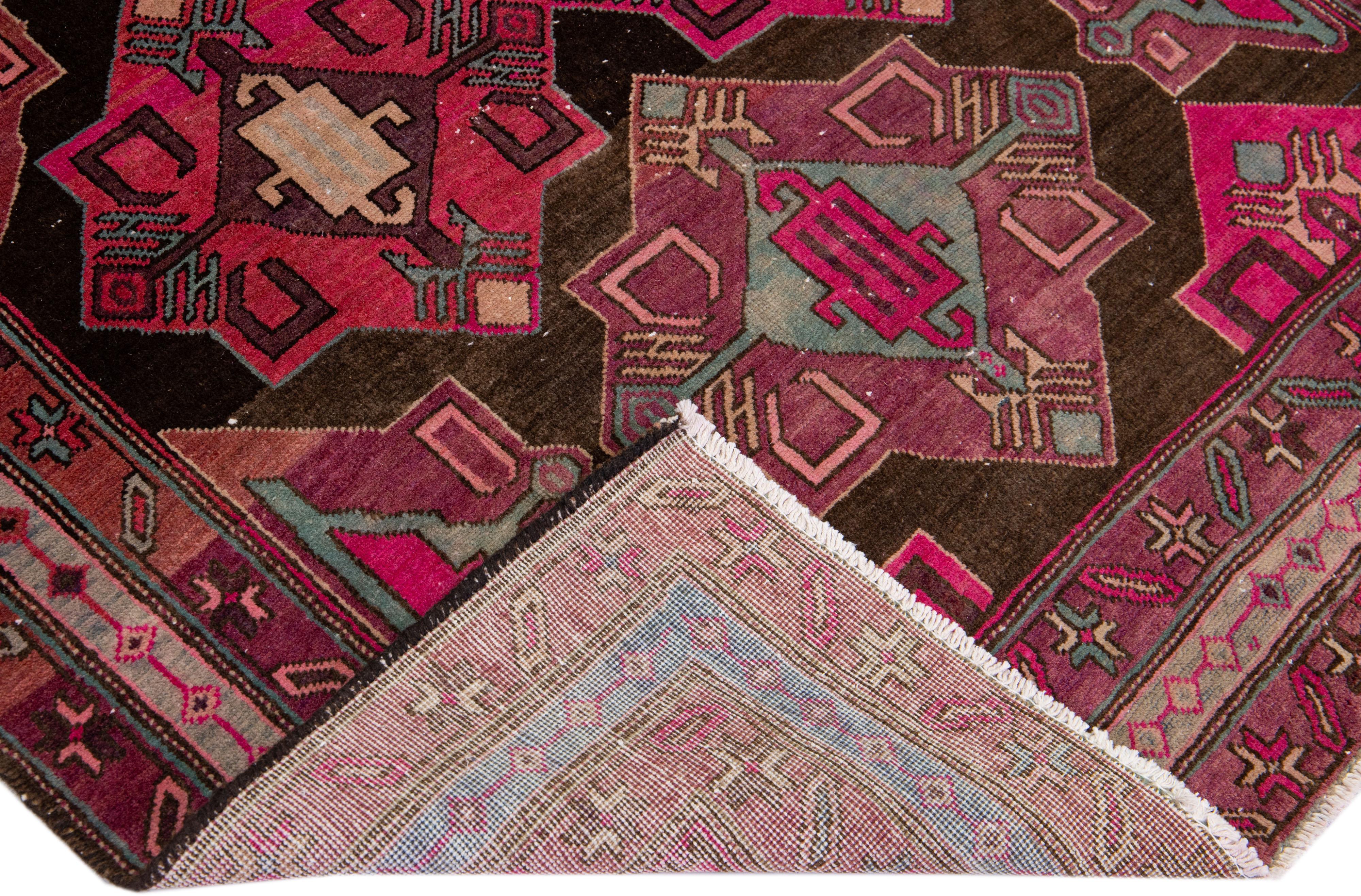 Beautiful Vintage Malayer hand-knotted wool rug with a brown color field. This Malayer piece has pink and teal accents in a gorgeous all-over geometric design.

This rug measures: 4'8